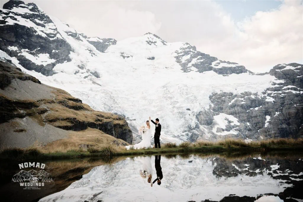 A picturesque elopement wedding in Queenstown, New Zealand captures a bride and groom with breathtaking lakeside and mountainous views.