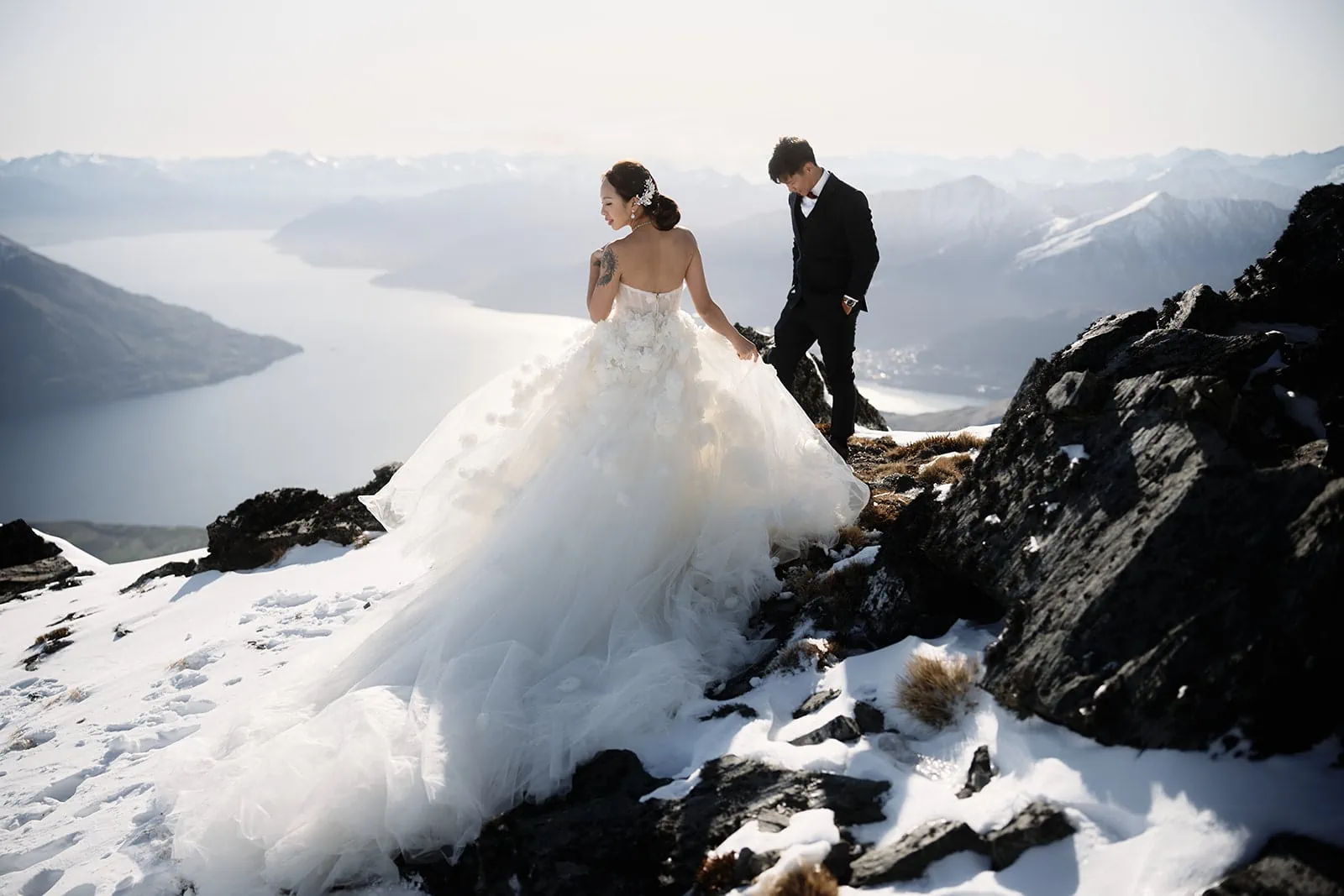 A bride and groom on top of a snow covered mountain in Queenstown, NZ.