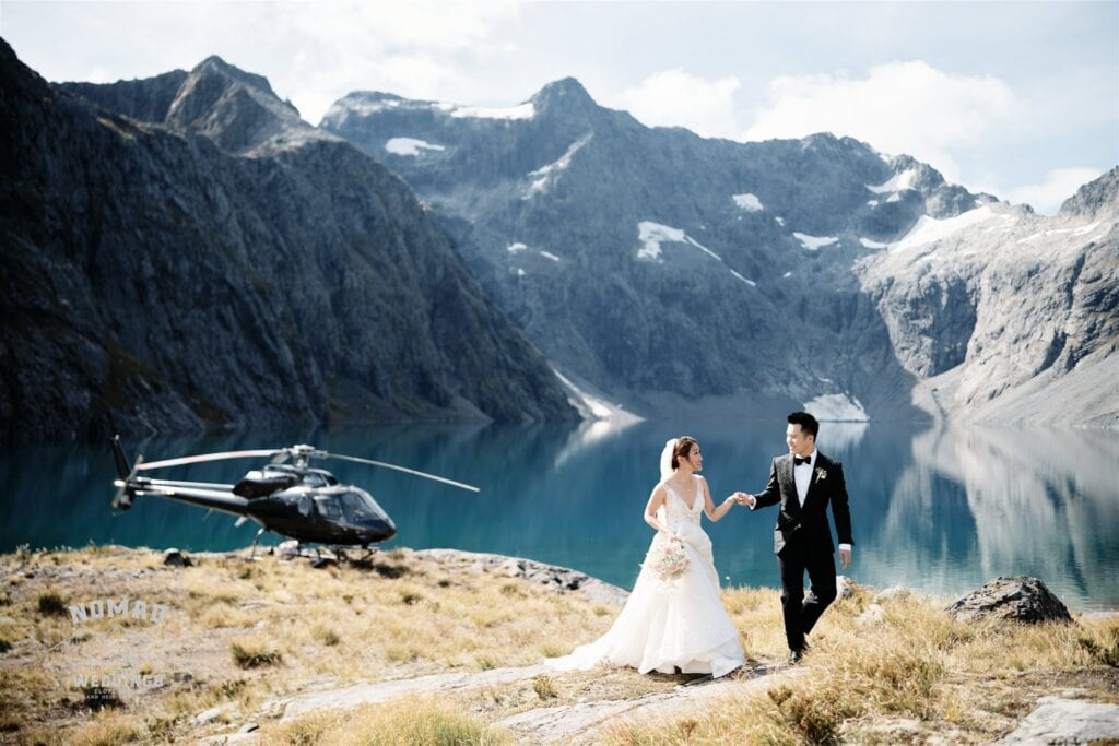 Queenstown New Zealand Elopement Wedding Photographer - A Queenstown heli wedding couple standing in front of a helicopter.