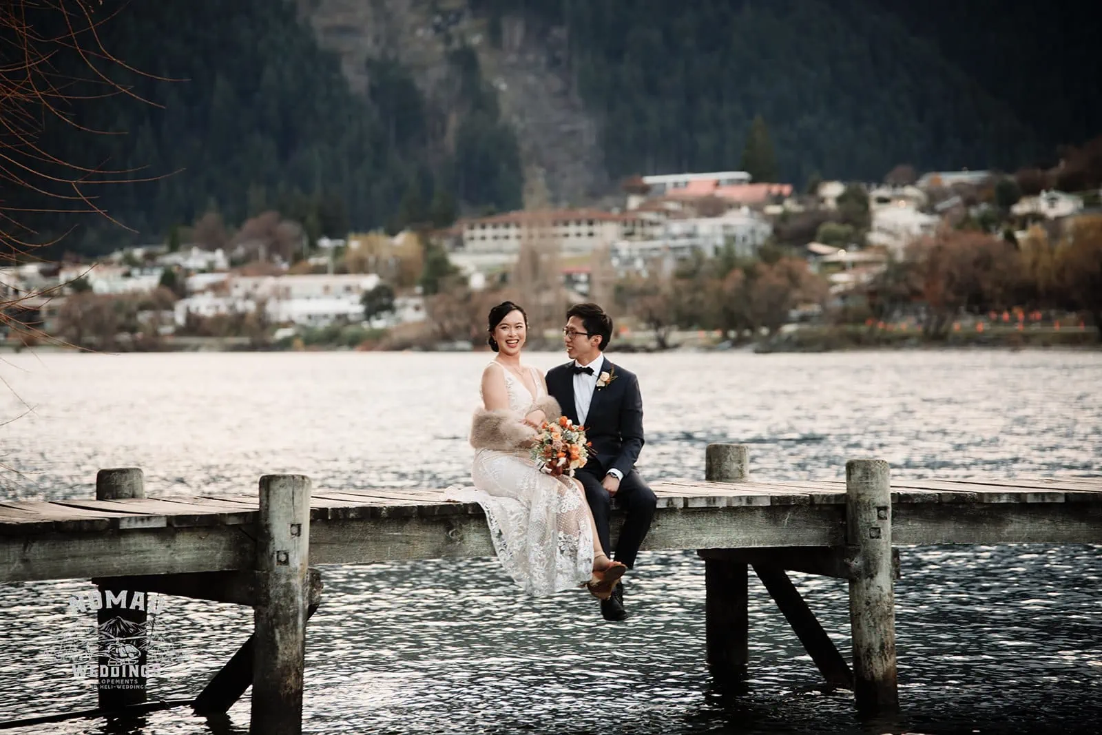 Joanna and Tony's pre-wedding shoot in Queenstown, New Zealand captures them sitting on a dock in front of a lake.