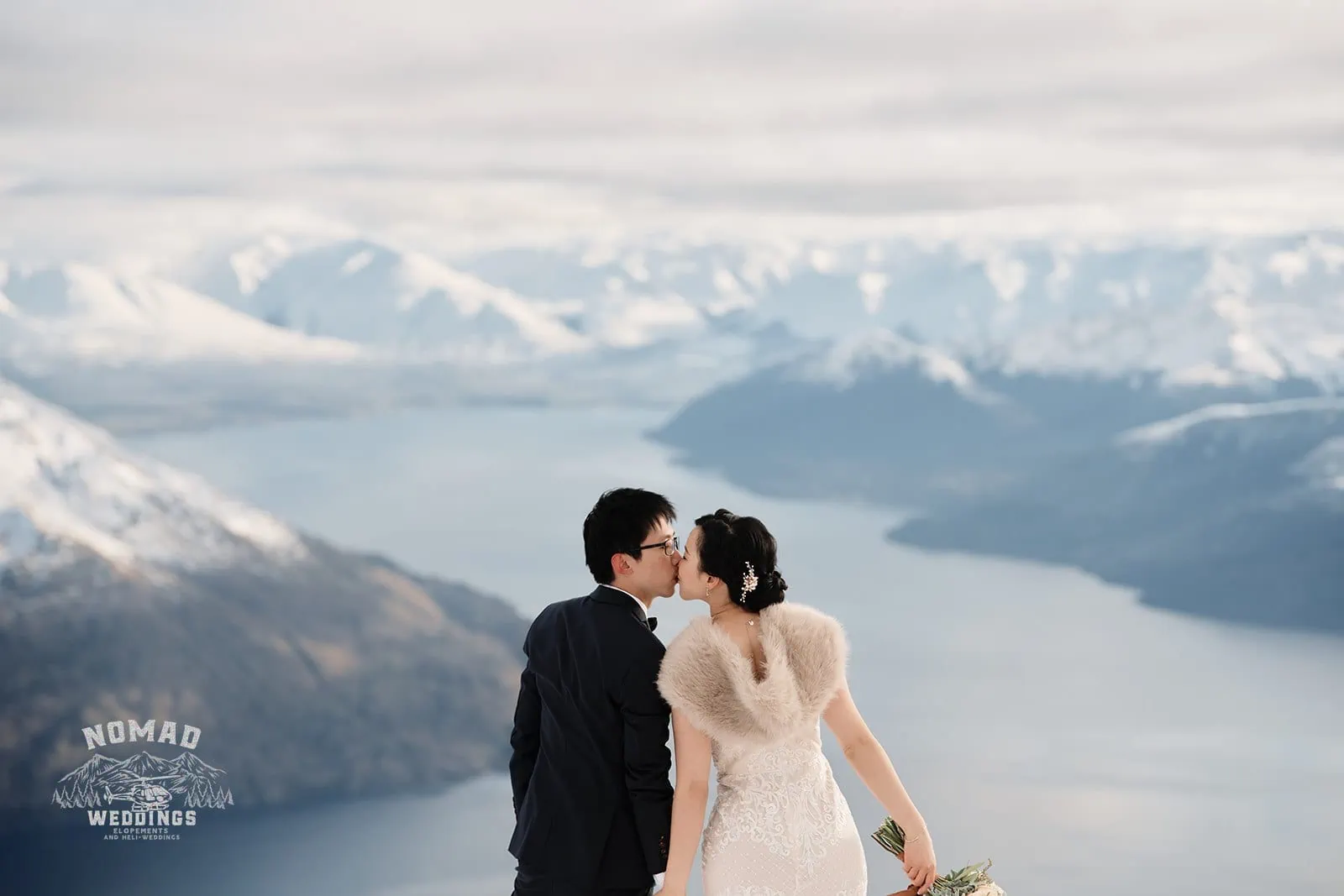 Joanna and Tony sharing a romantic moment during their pre-wedding shoot atop Queenstown's mesmerizing mountain with a panoramic view of Lake Wanaka.