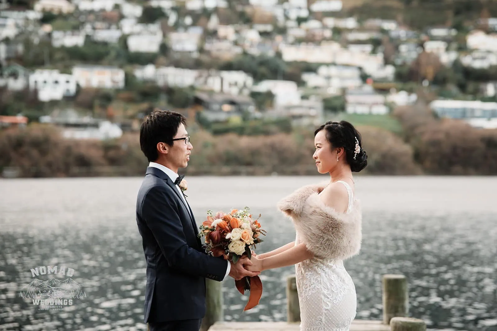 Joanna and Tony, a bride and groom, posing on a dock for their pre-wedding shoot in Queenstown, New Zealand.