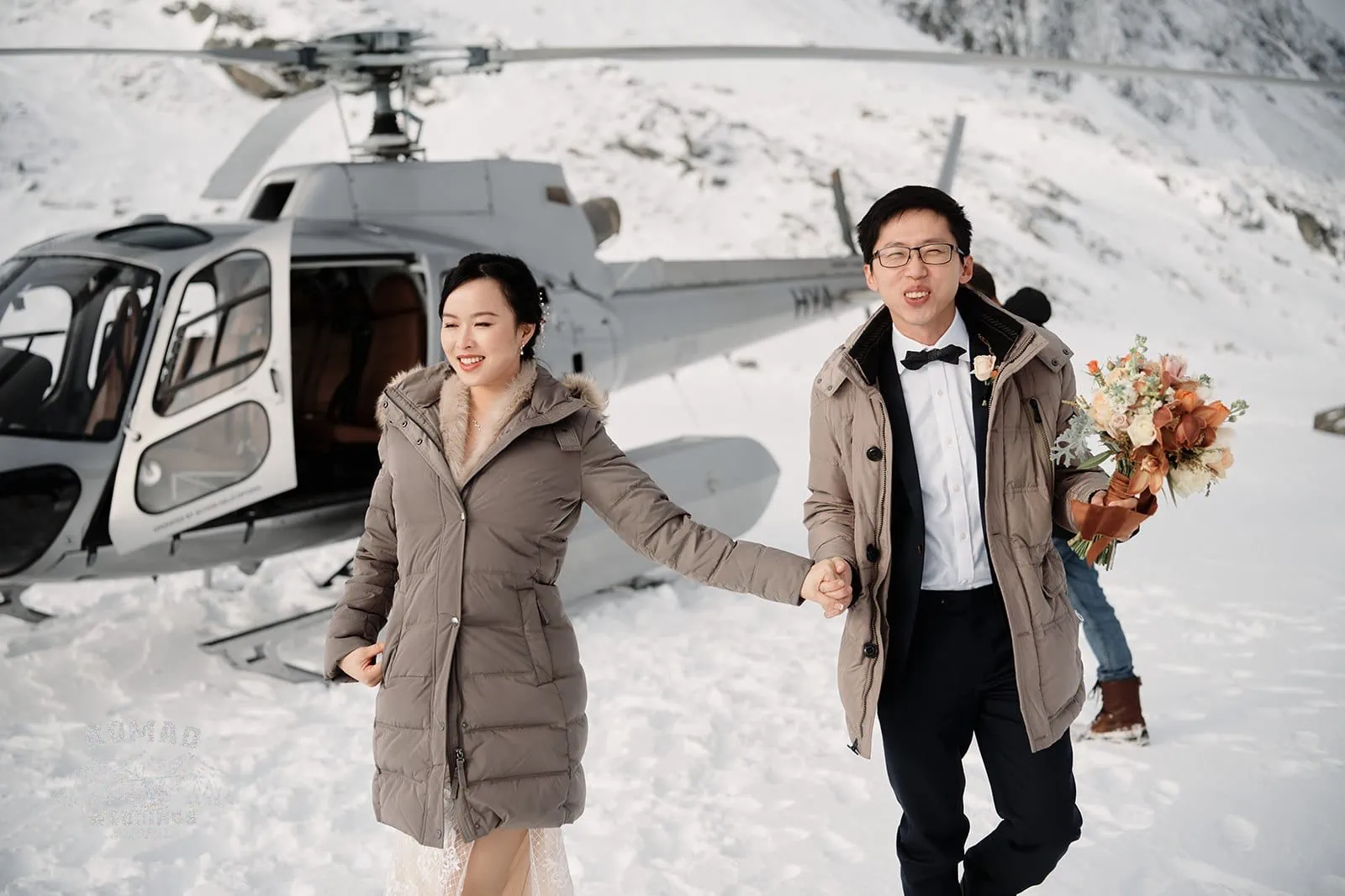 Joanna and Tony share a loving moment during their Pre-wedding Shoot in Queenstown, New Zealand, as they hold hands in front of a helicopter.