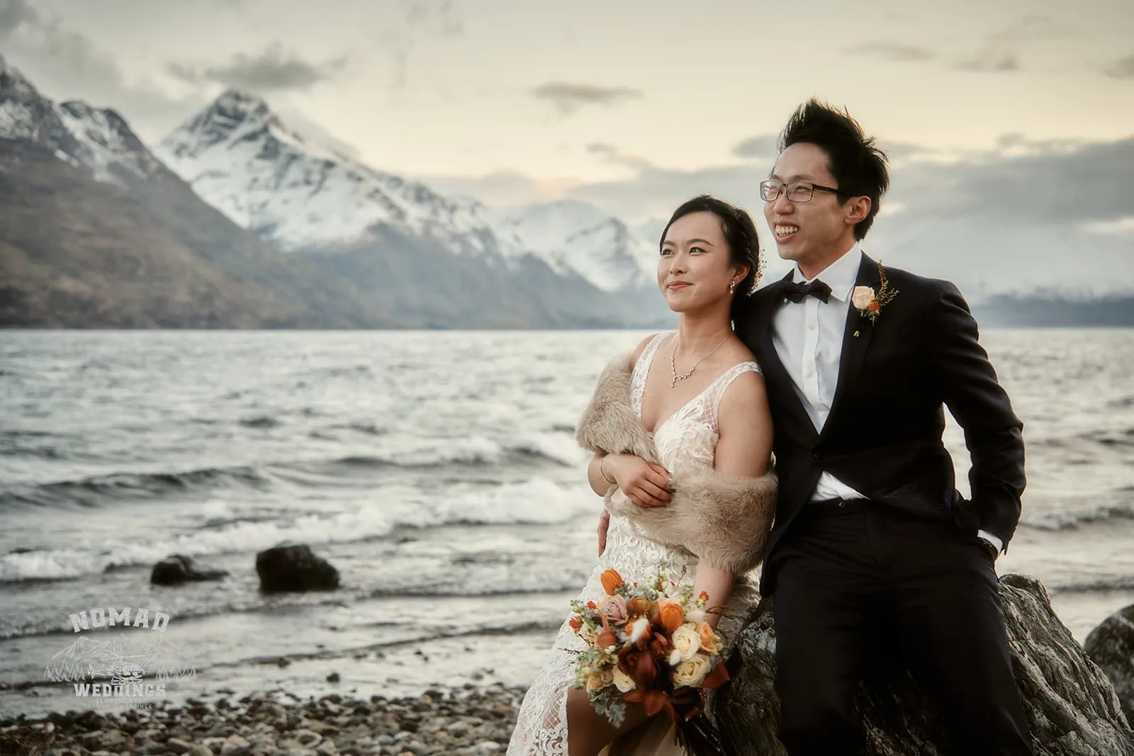 Joanna and Tony posing for a pre-wedding shoot in front of a lake in Queenstown, New Zealand.