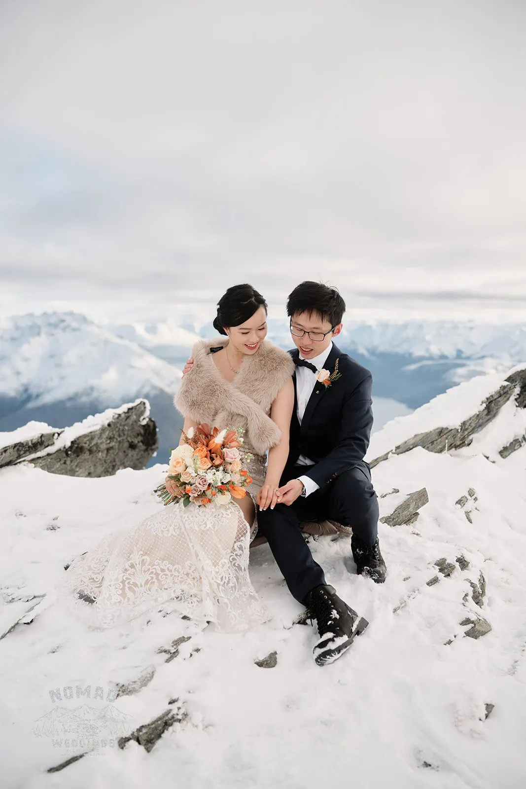 Joanna and Tony, a bride and groom, taking their pre-wedding shoot on top of a snow covered mountain in Queenstown, New Zealand.