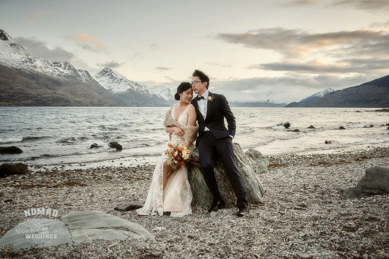 Joanna and Tony, the bride and groom, posing in Queenstown, New Zealand during their pre-wedding shoot near a lake.