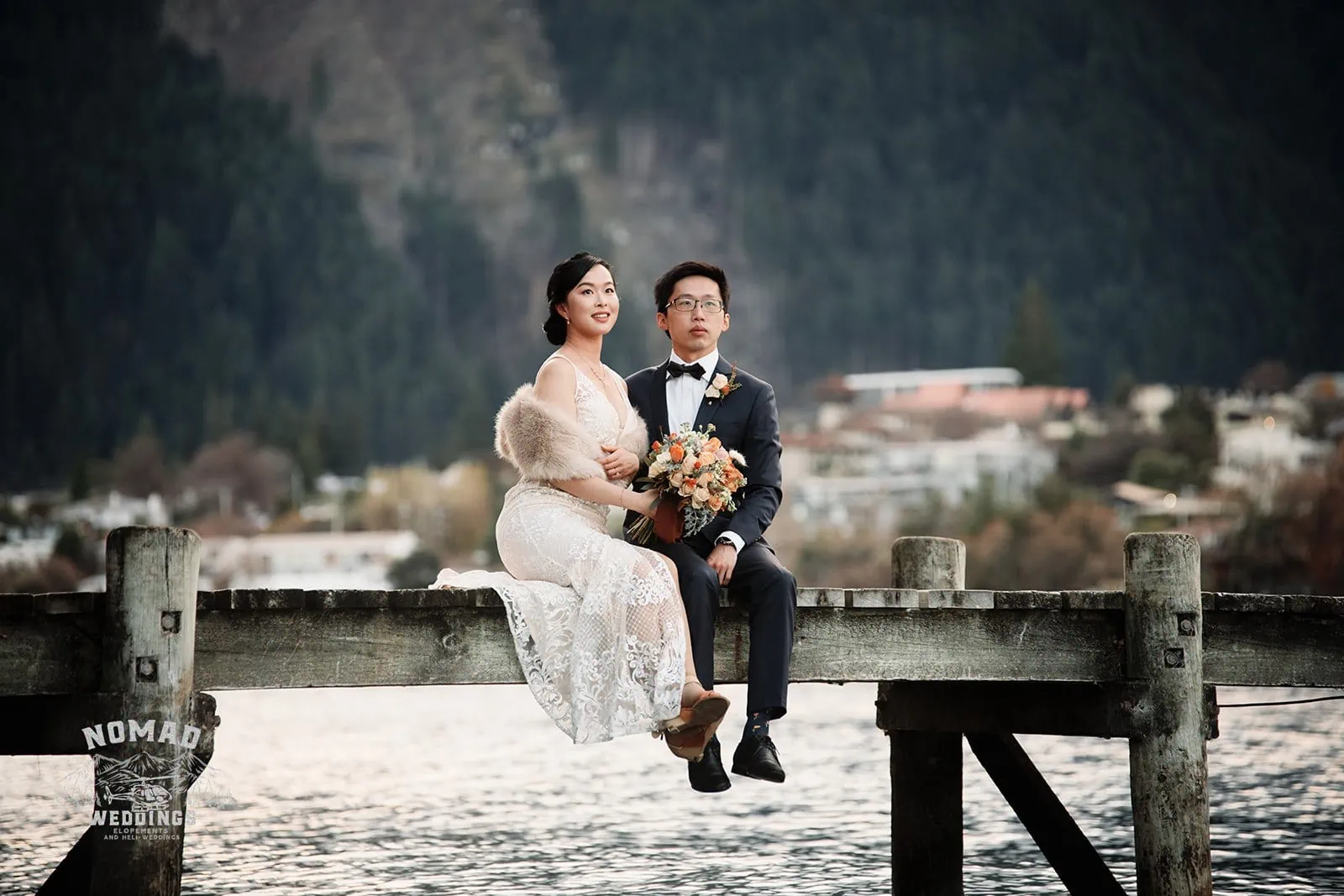 Joanna and Tony's pre-wedding shoot in Queenstown, New Zealand, featuring a bride and groom sitting on a pier with mountains in the background.