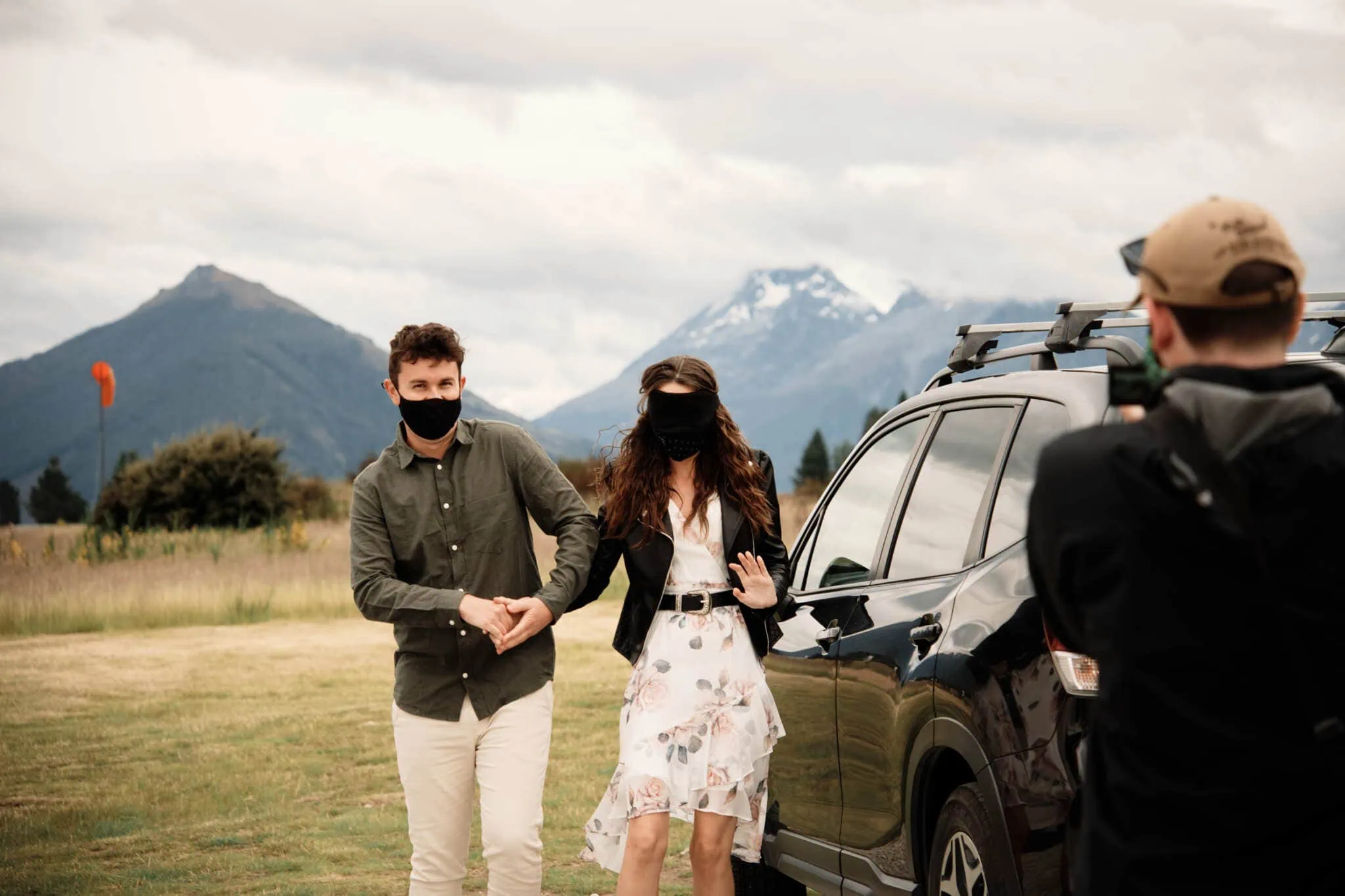 Scott and Hayley standing next to a car in front of mountains.