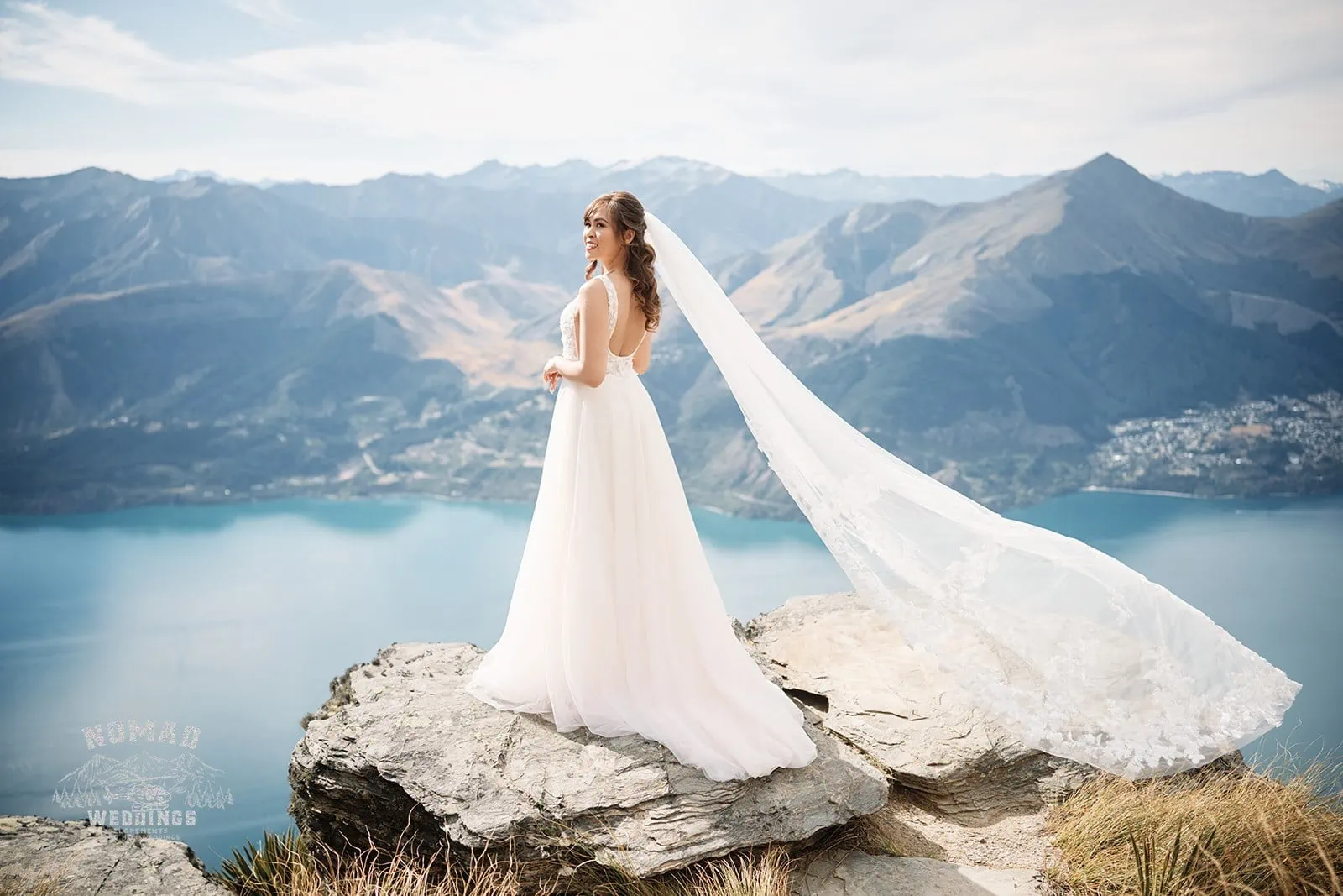 Nhi and Nicholas' pre-wedding shoot at Cecil Peak in Queenstown, New Zealand, with the bride overlooking Lake Wanaka from a mountain top.