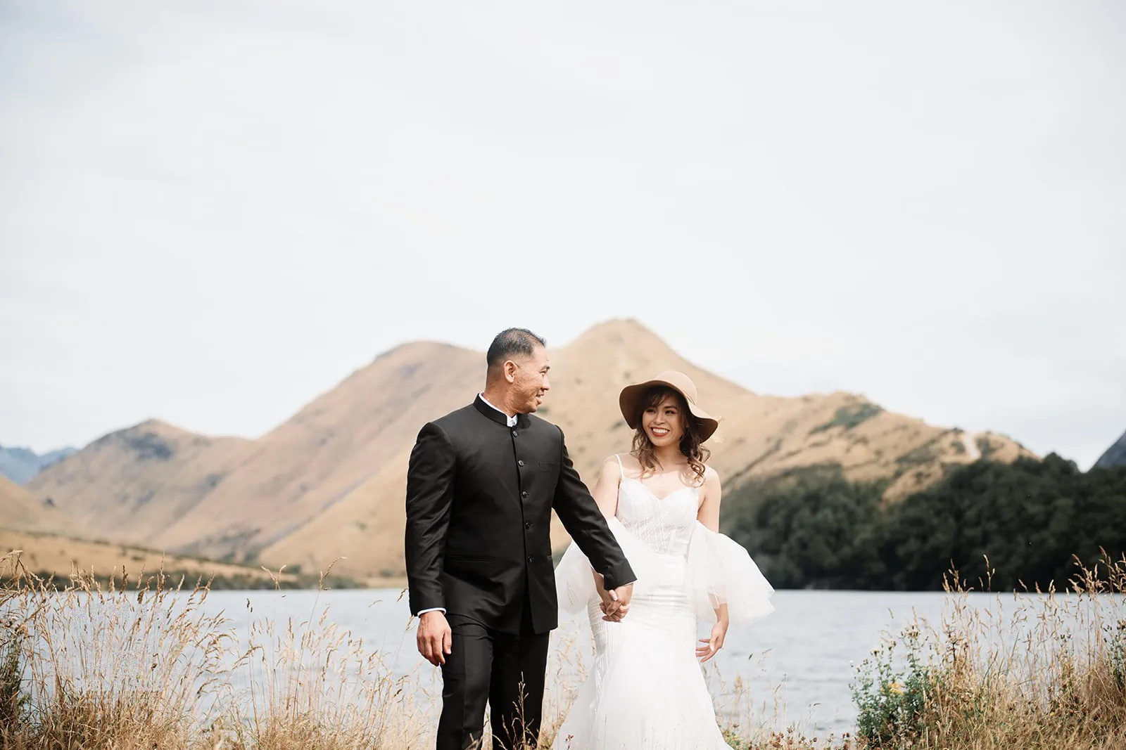A pre-wedding shoot featuring Nhi and Nicholas, set against the stunning backdrop of Queenstown's Cecil Peak with a lake and mountains.