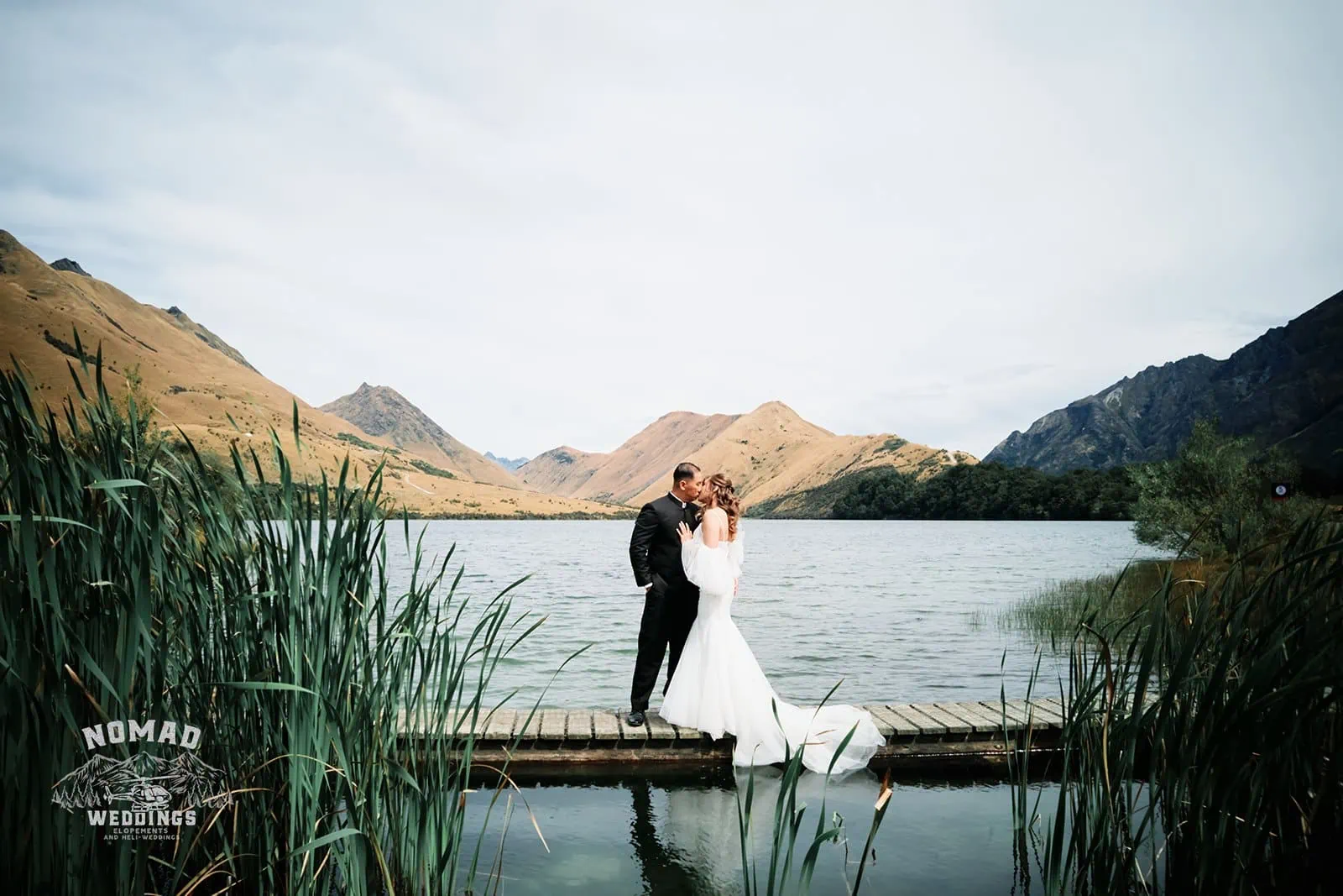 A bride and groom sharing a romantic kiss during their Queenstown NZ pre-wedding shoot near Cecil Peak.