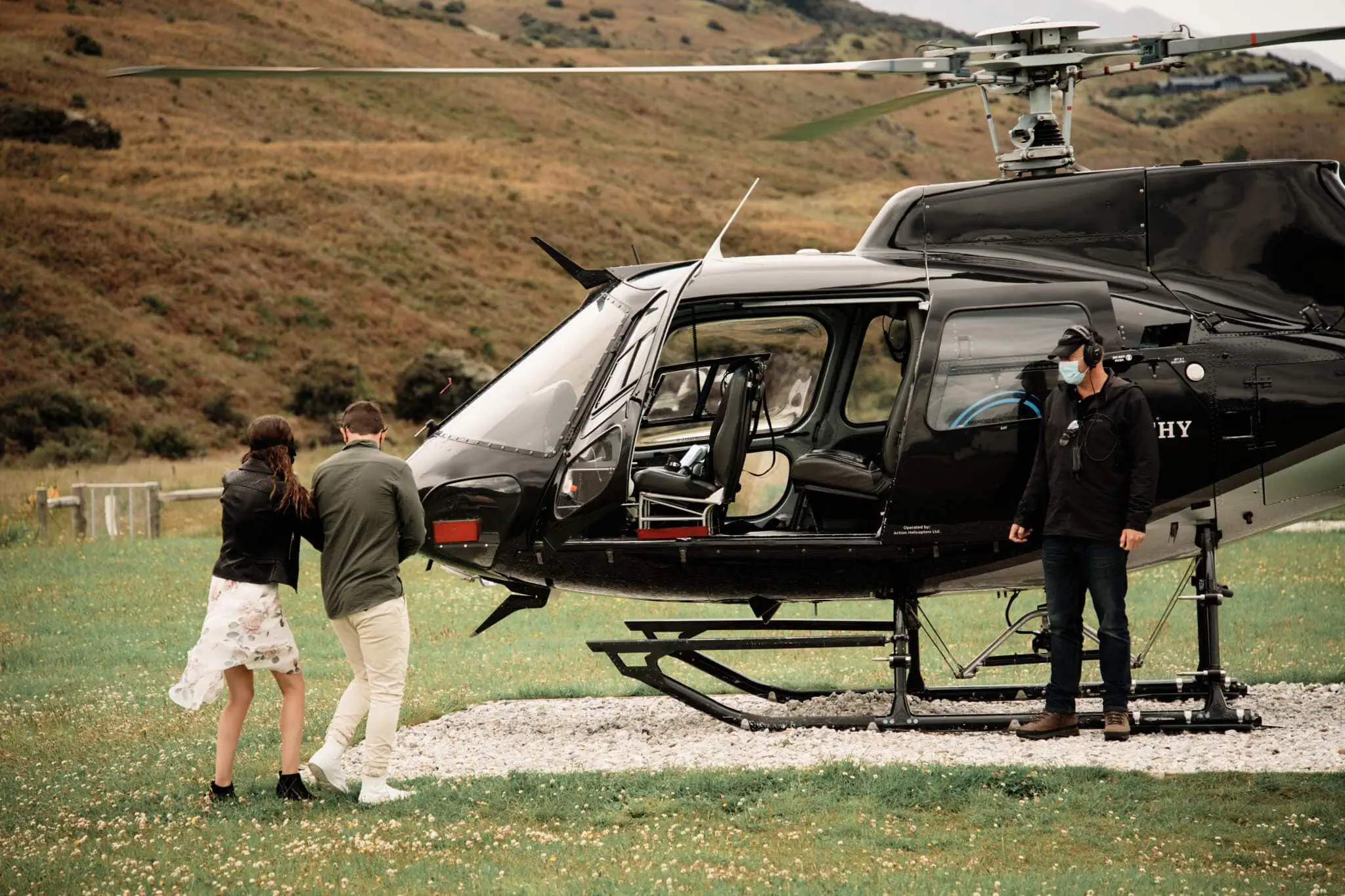 Scott and Hayley standing next to a black helicopter.