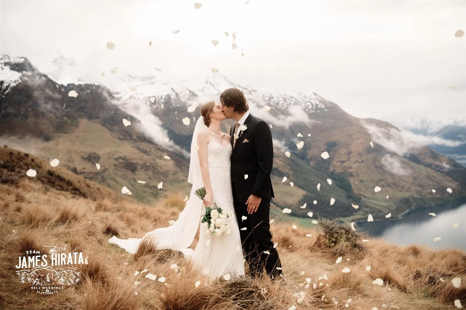 Hannah and Ross eloped on top of a mountain in Queenstown, New Zealand, sharing a romantic kiss as confetti surrounded them.