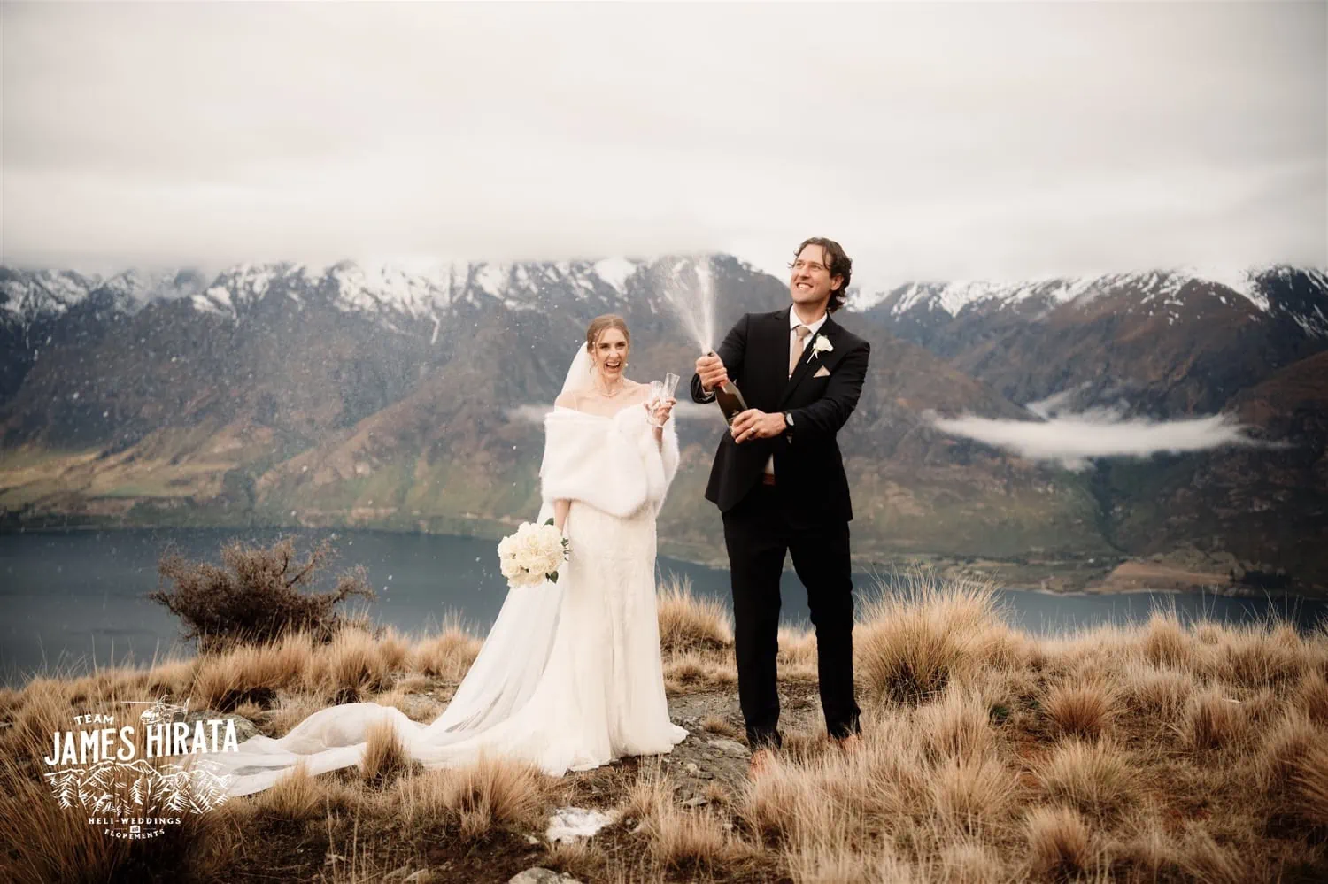 Hannah and Ross Elopement Wedding: A couple blowing bubbles on top of a mountain in Queenstown, New Zealand.