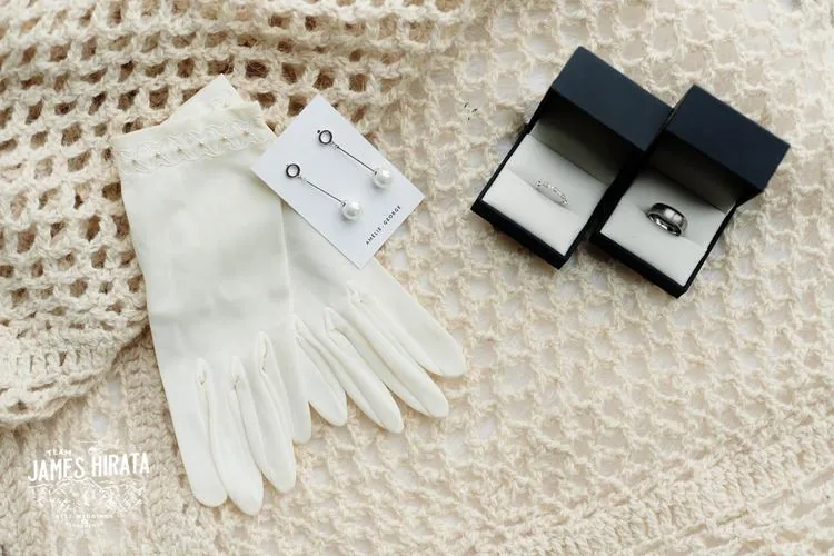 Regan and Jake's Queenstown elopement wedding featuring a pair of gloves and a pair of earrings on a blanket.