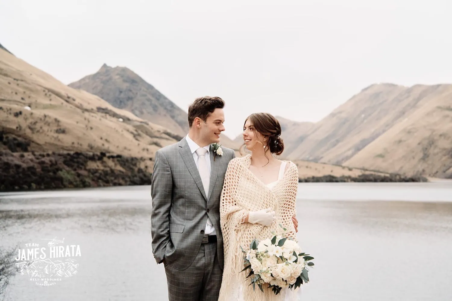 Regan & Jake exchange vows at their Queenstown elopement wedding, with a stunning lake backdrop in New Zealand.