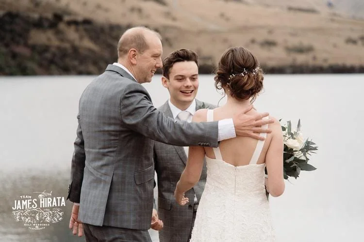 Regan and Jake embracing in front of a picturesque lake for their Queenstown elopement wedding.