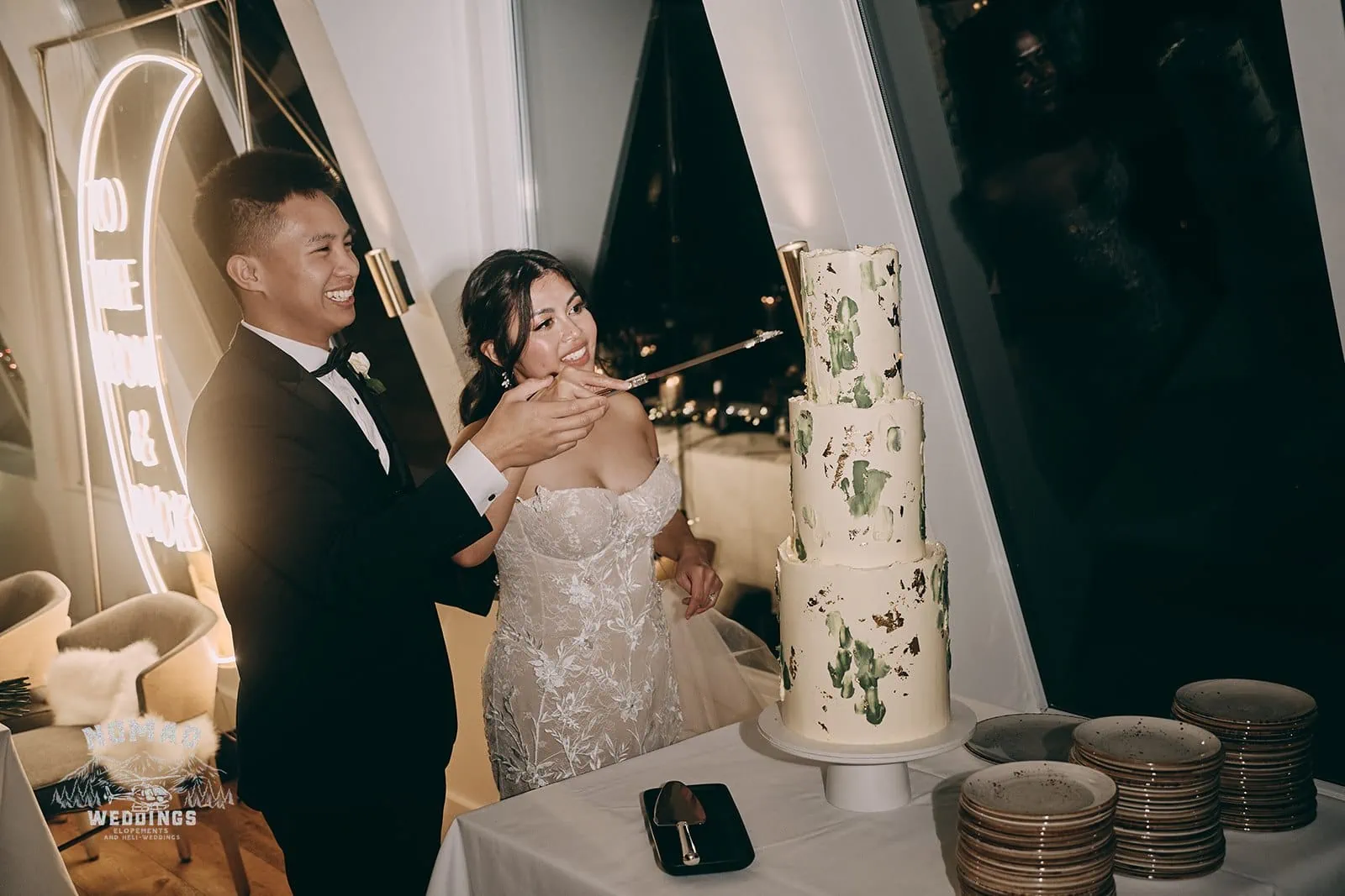 A couple cutting their wedding cake at night.