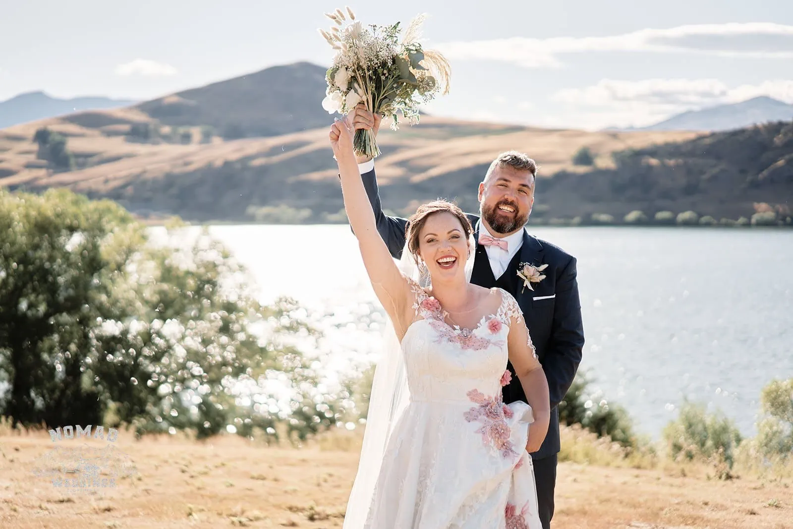 Queenstown New Zealand Elopement Wedding Photographer - A bride and groom holding bouquets in front of a lake - QUEENSTOWN SUMMER WEDDING