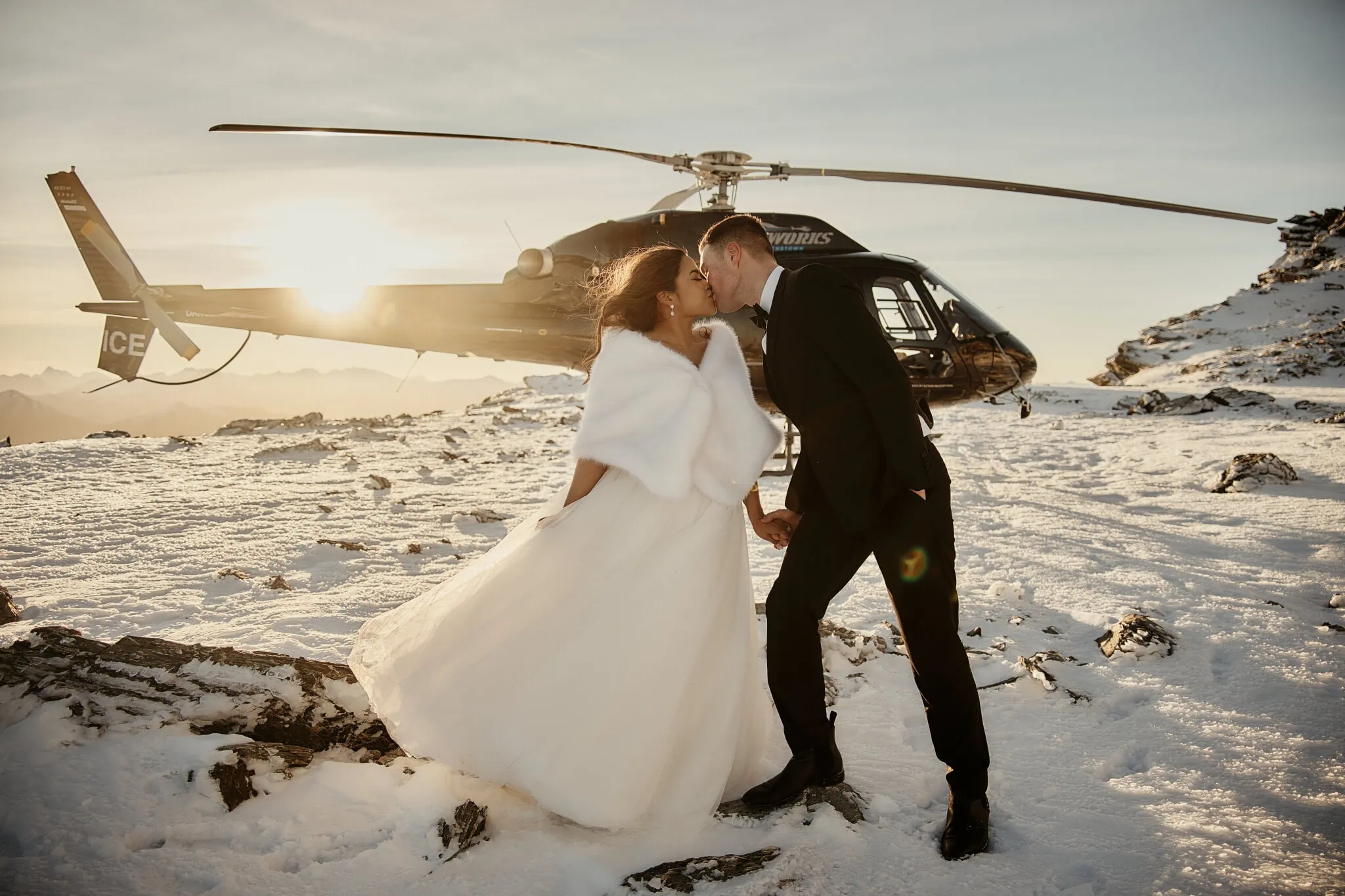Queenstown New Zealand Elopement Wedding Photographer - Amy and Callum have a romantic Queenstown Heli pre-wedding shoot, captured in a kiss in front of a helicopter.
