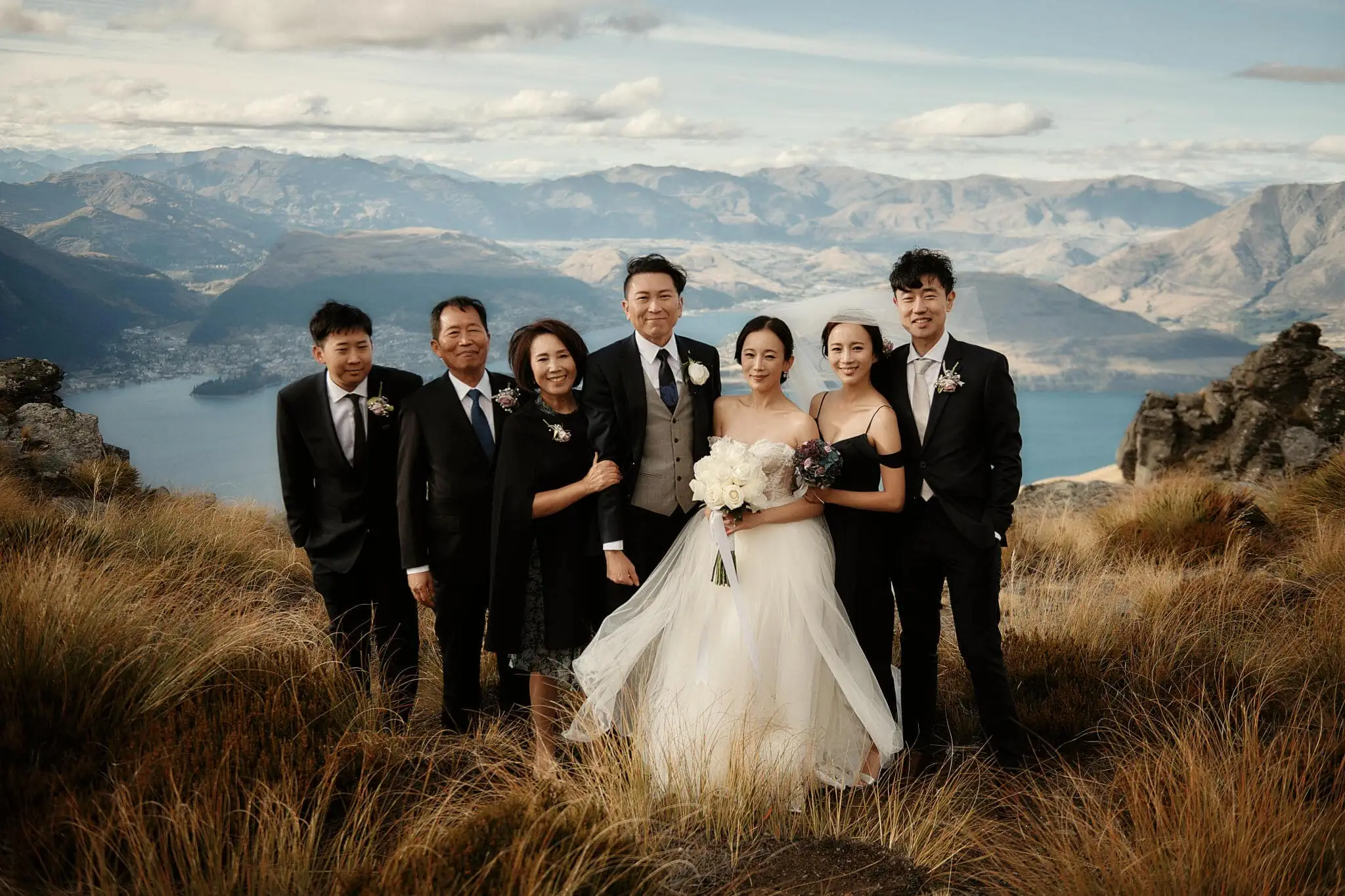 Queenstown New Zealand Elopement Wedding Photographer - Sarah and Tim having a scenic Queenstown heli elopement wedding, posing on top of a mountain in New Zealand.