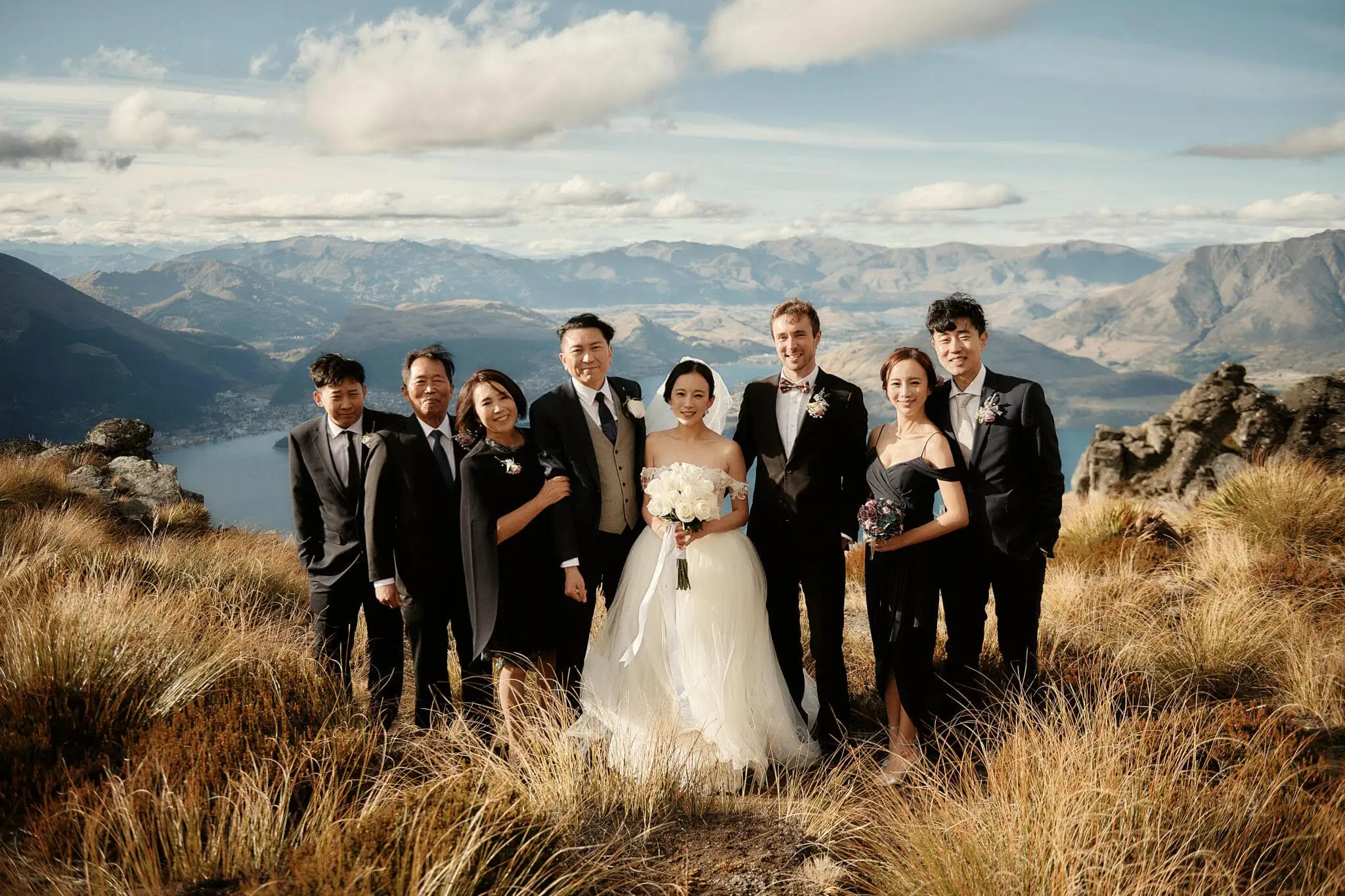 Queenstown New Zealand Elopement Wedding Photographer - Sarah and Tim's scenic Queenstown heli elopement wedding, with the wedding party posing on top of a mountain in New Zealand.
