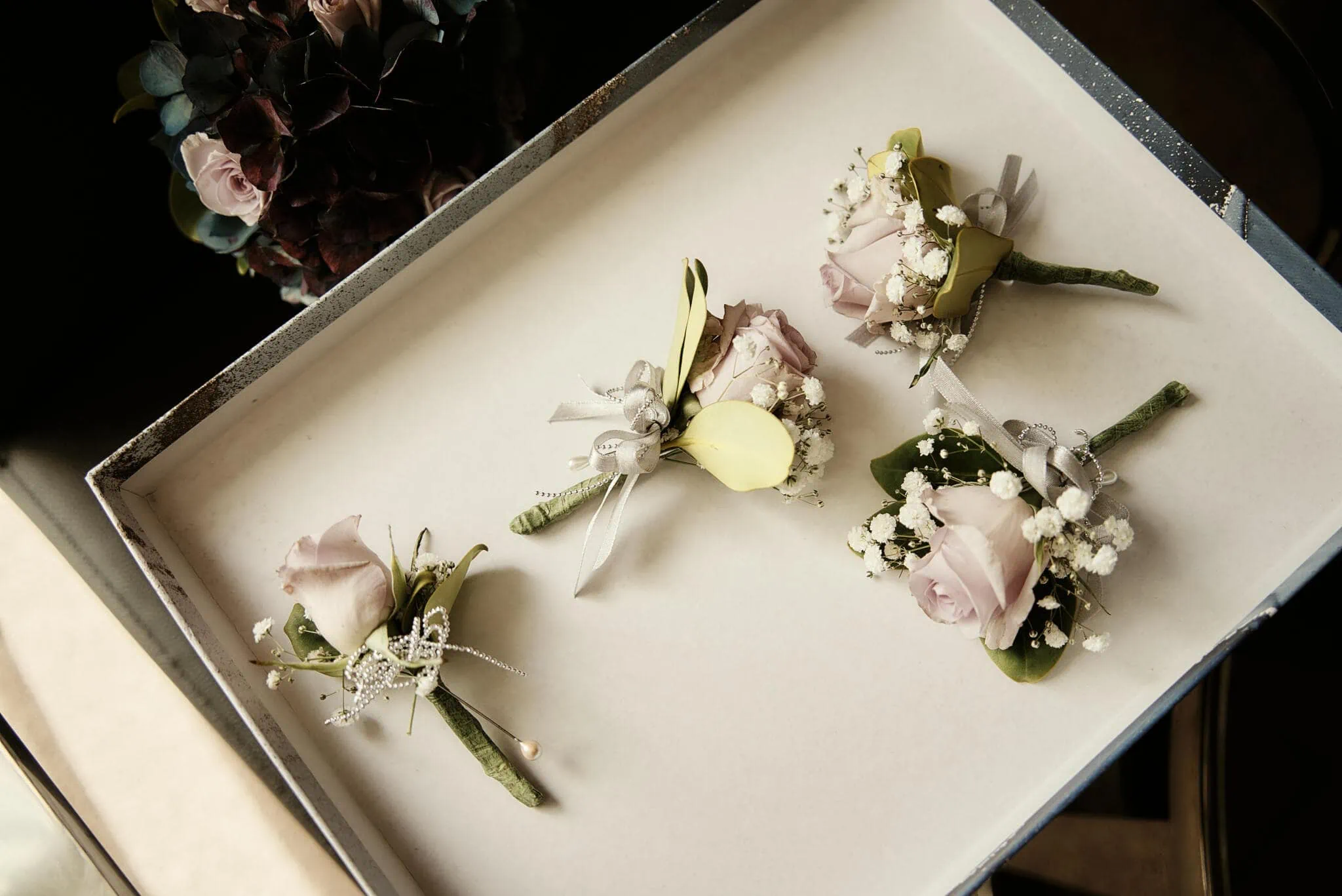 Queenstown New Zealand Elopement Wedding Photographer - Four boutonnieres on a table at Sarah and Tim's Scenic Queenstown Heli Elopement Wedding.