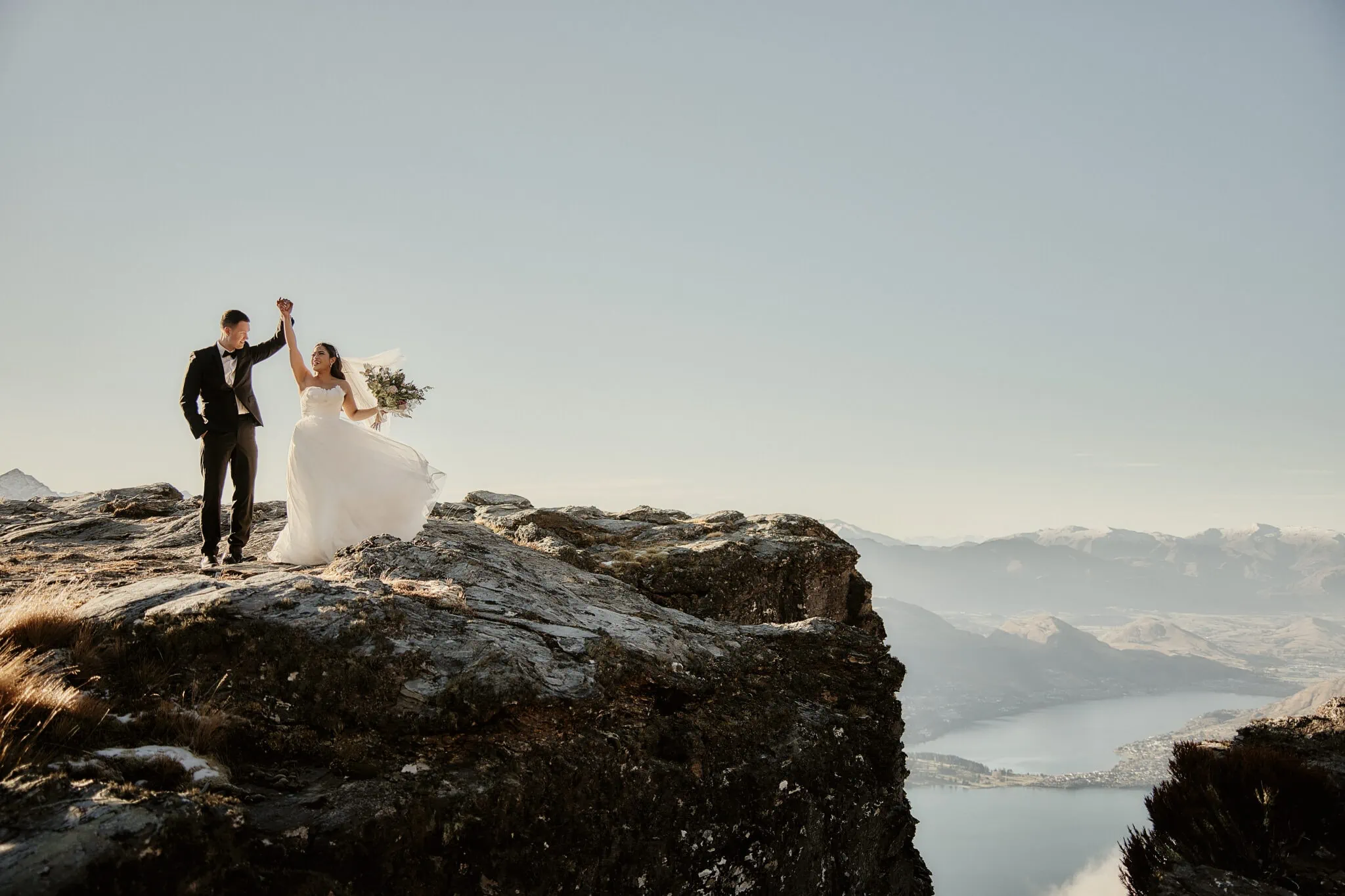 Queenstown New Zealand Elopement Wedding Photographer - Amy and Callum's Queenstown Heli Pre Wedding Shoot takes them to a cliff in New Zealand.