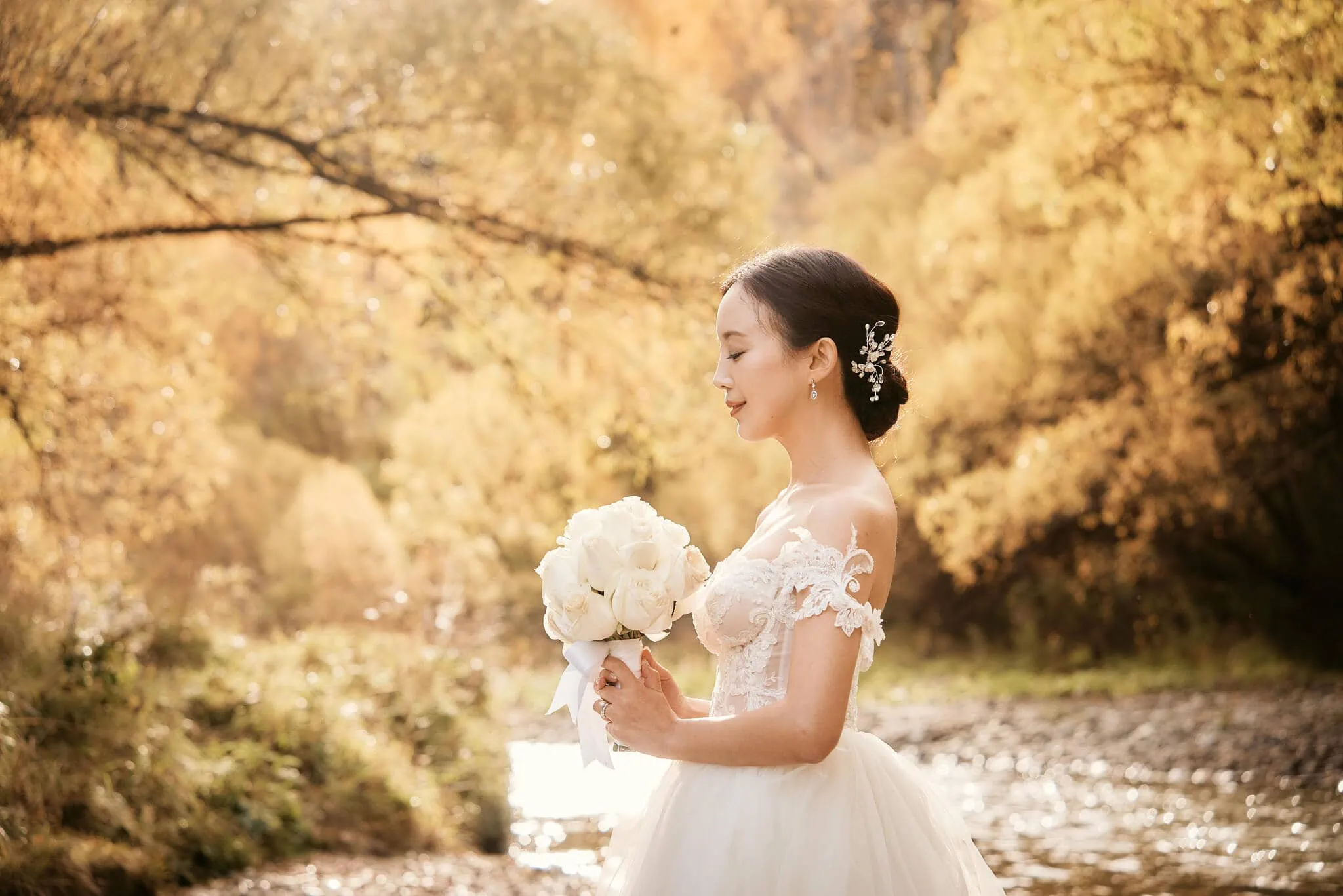 Queenstown New Zealand Elopement Wedding Photographer - Sarah and Tim's scenic Queenstown heli elopement wedding, with a bride in a wedding dress standing by a river.
