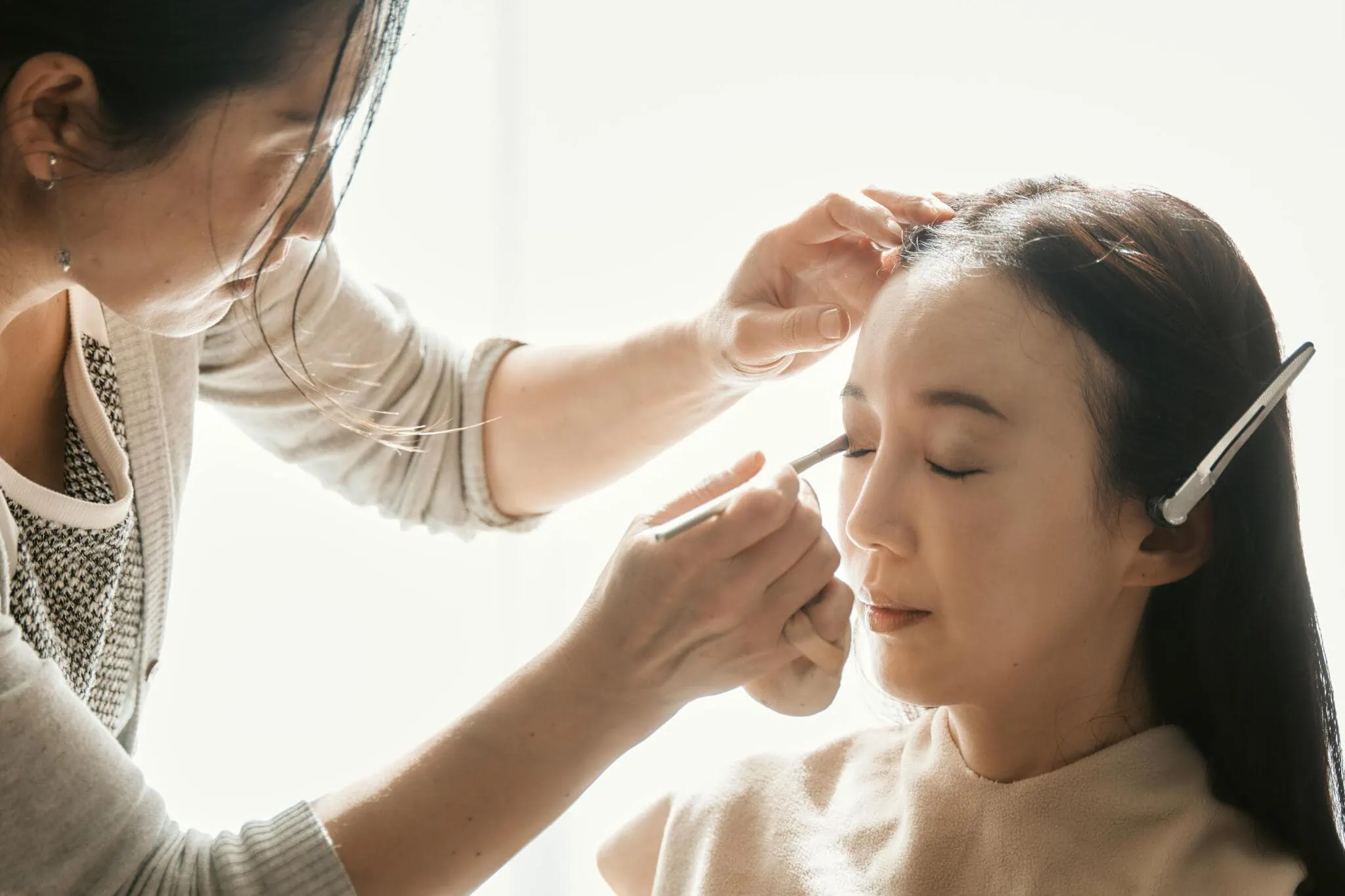 Queenstown New Zealand Elopement Wedding Photographer - A woman receiving professional makeup from another woman at a Scenic Queenstown Heli Elopement Wedding.