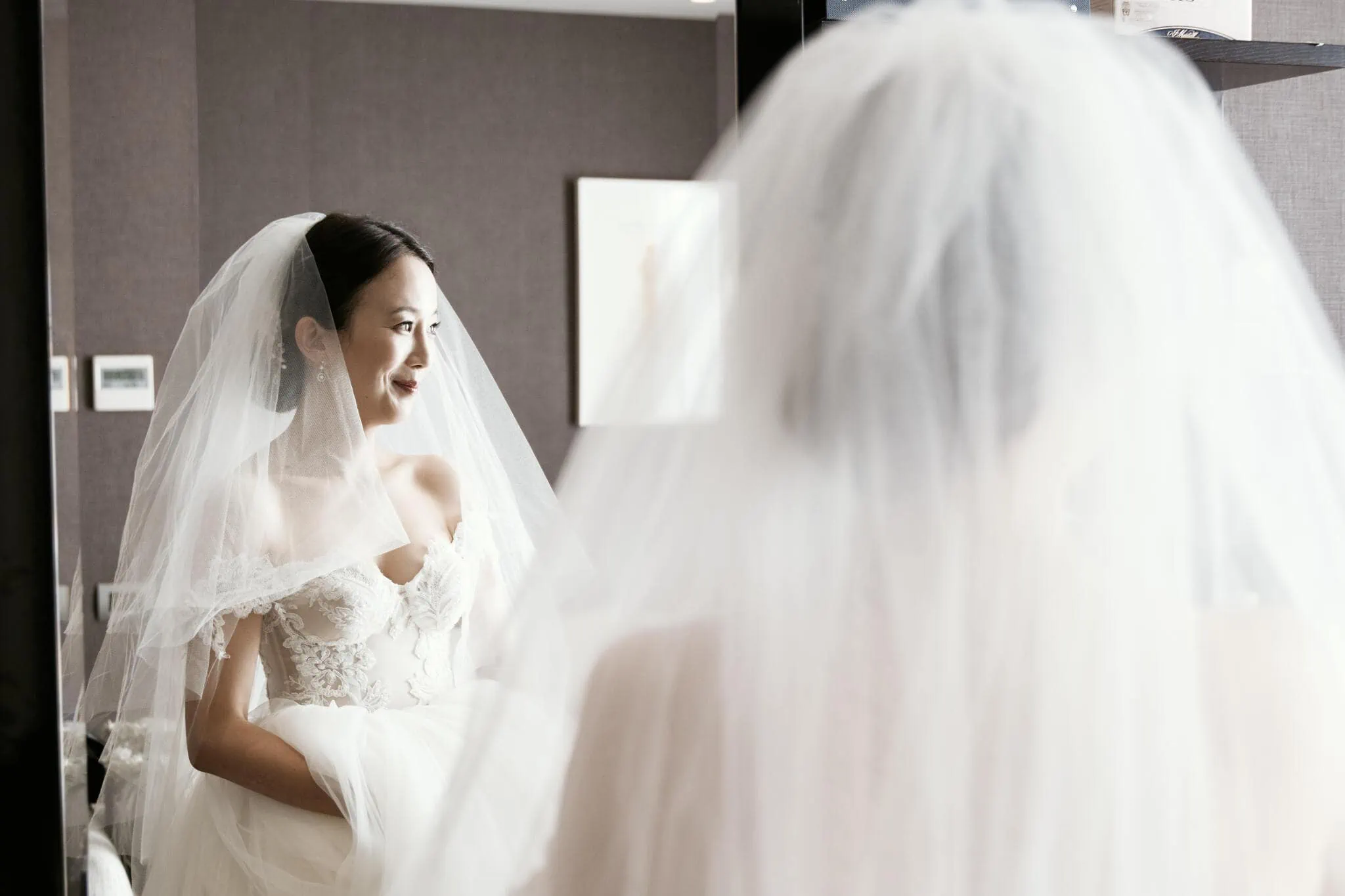 Queenstown New Zealand Elopement Wedding Photographer - Sarah, a bride in a wedding dress, admiring herself in the mirror during her Scenic Queenstown Heli Elopement Wedding.