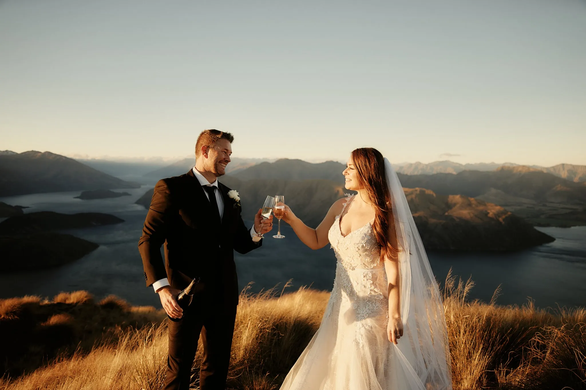 Queenstown New Zealand Elopement Wedding Photographer - Ashleigh and Anthony toasting champagne on top of Roy's Peak overlooking Lake Wanaka for their heli elopement wedding.