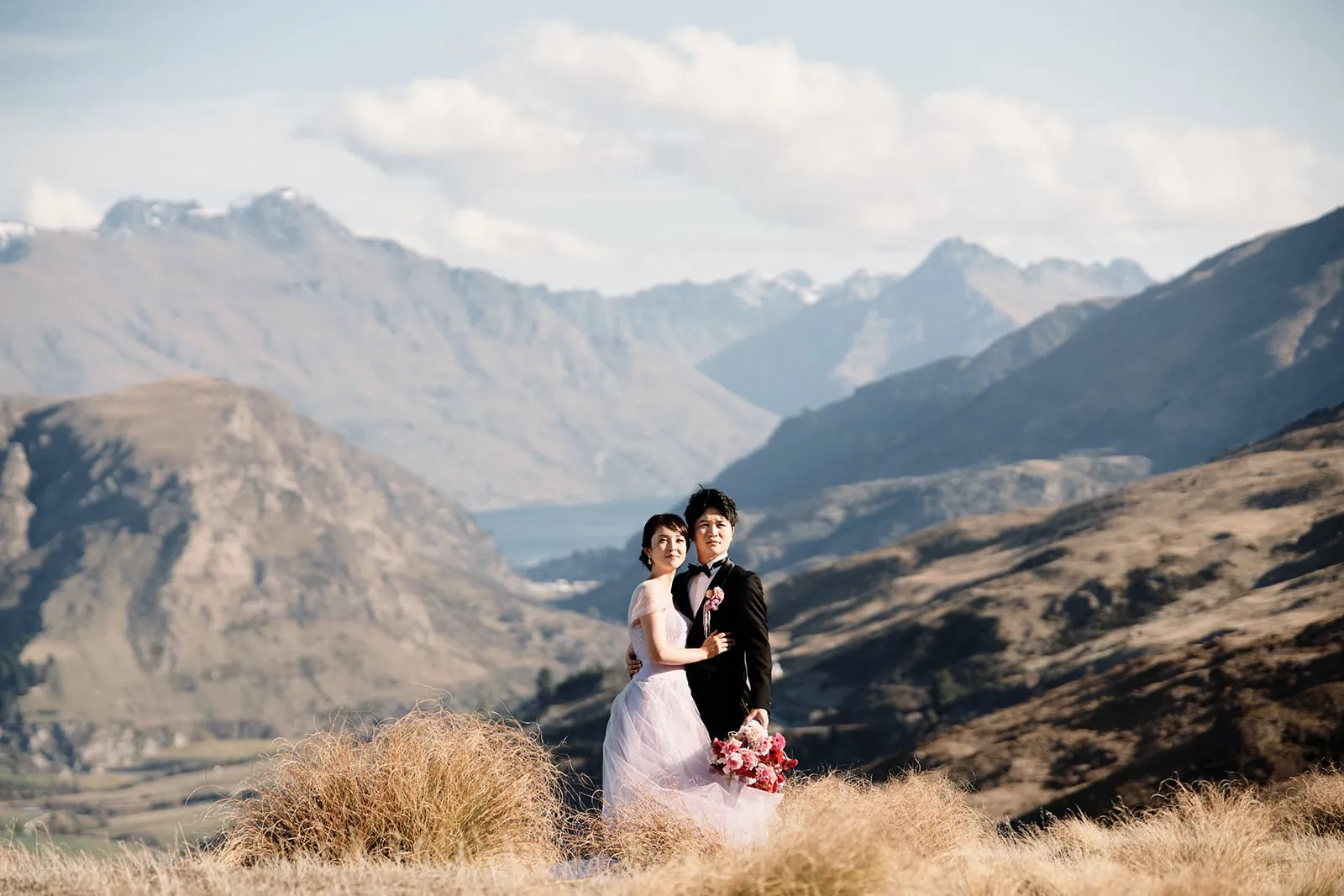 Queenstown New Zealand Elopement Wedding Photographer - A summer bride and groom standing in front of a mountain in Queenstown, New Zealand.