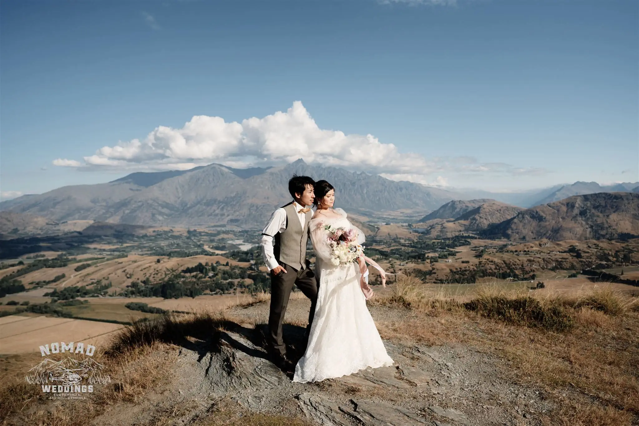 Queenstown New Zealand Elopement Wedding Photographer - A bride and groom standing on top of a mountain in Queenstown, New Zealand.