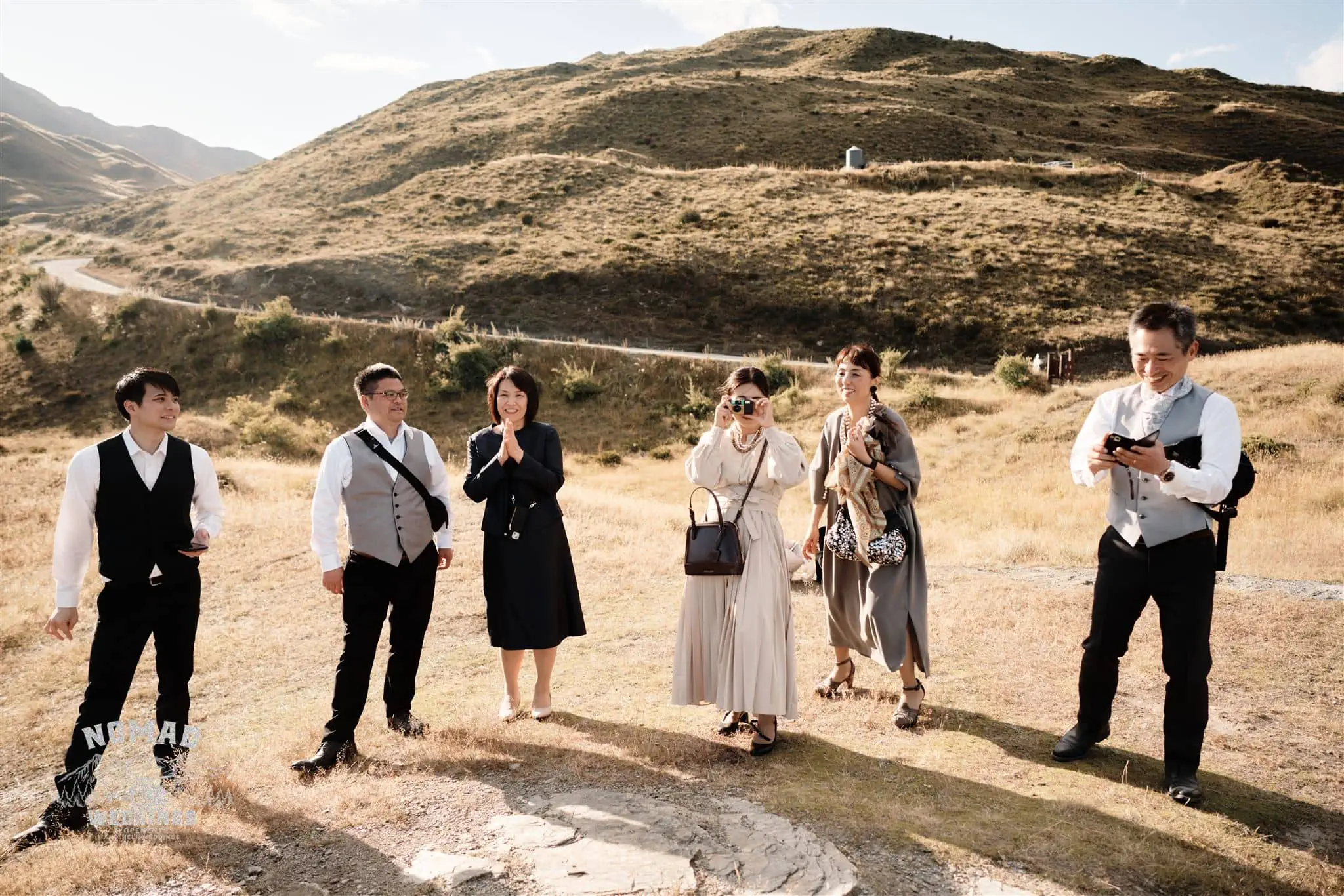 Queenstown New Zealand Elopement Wedding Photographer - A group of people posing for a picture in the mountains while exploring Queenstown's summer ground spots.