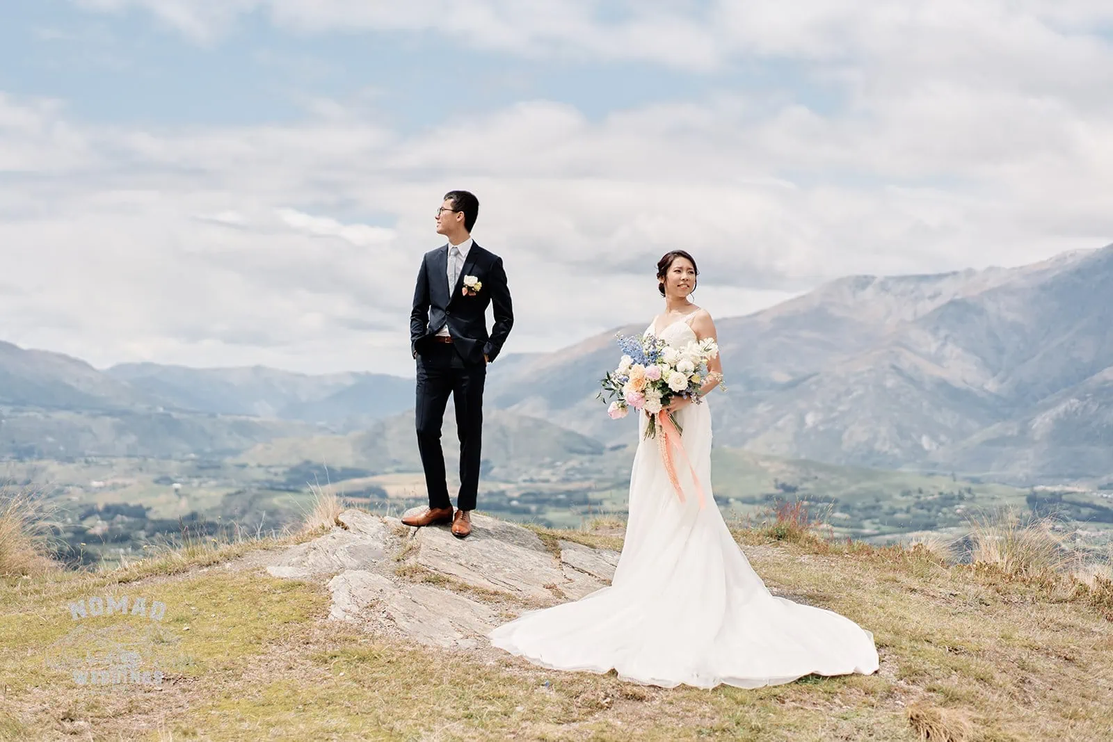 Queenstown New Zealand Elopement Wedding Photographer - A couple standing on top of a hill with mountains in the background.
