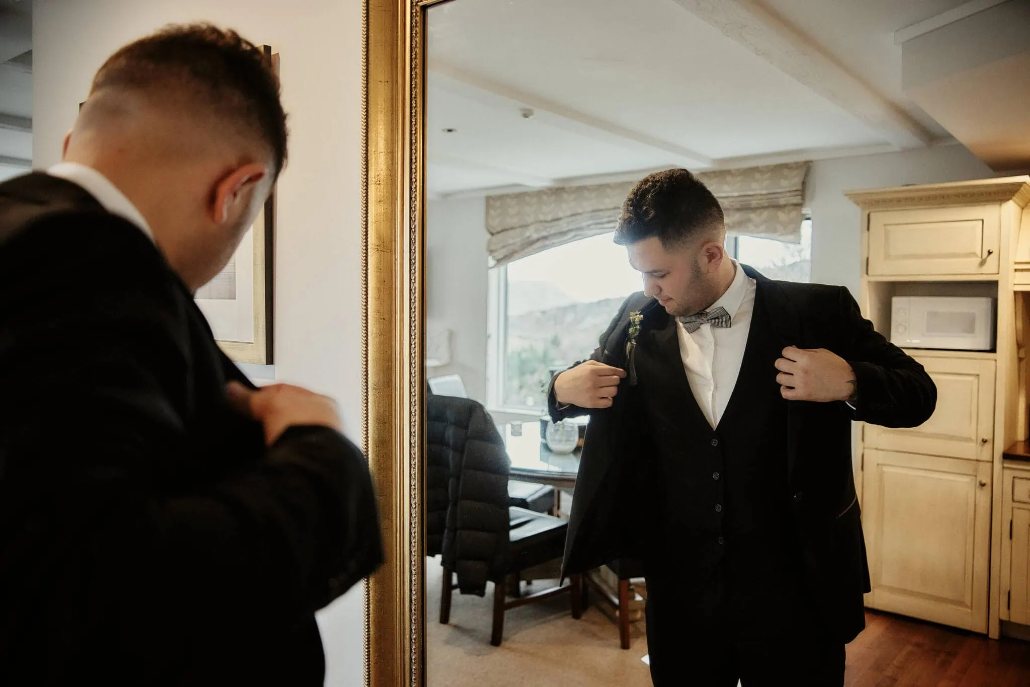Queenstown New Zealand Elopement Wedding Photographer - A man is getting dressed in a tuxedo for his Caitiann and Kiyo's Coronet Peak elopement wedding.