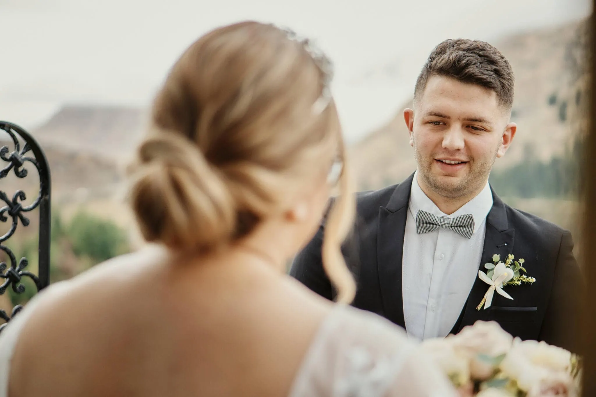 Queenstown New Zealand Elopement Wedding Photographer - Caitiann and Kiyo eloping at Coronet Peak, gazes lovingly at each other against the backdrop of a majestic mountain.