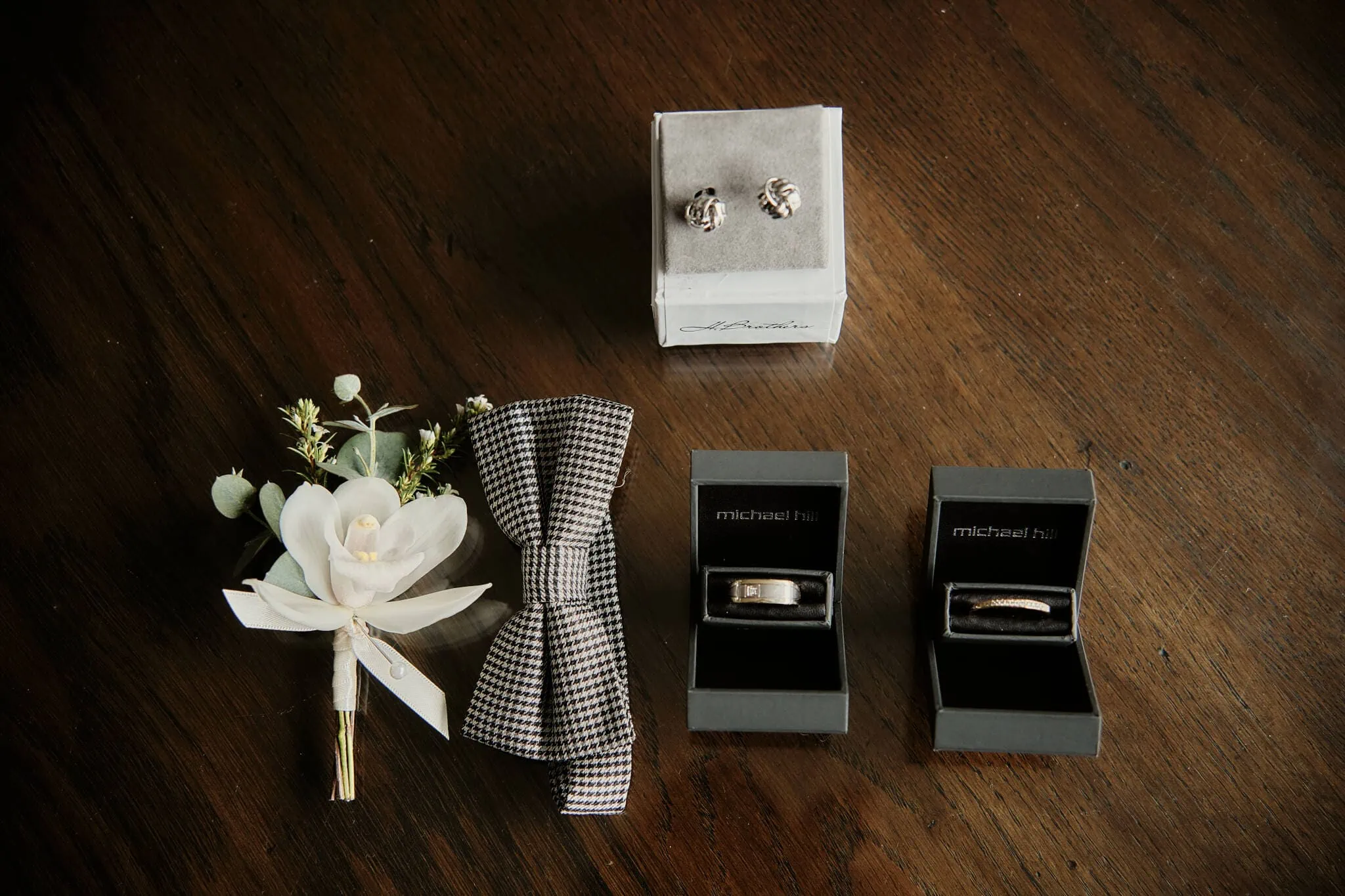 Queenstown New Zealand Elopement Wedding Photographer - Caitiann and Kiyo's elopement wedding at Coronet Peak featured a wedding ring and a flower on a table.