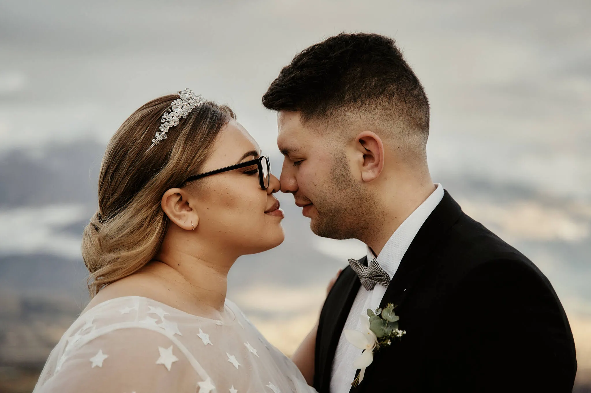 Queenstown New Zealand Elopement Wedding Photographer - Caitiann and Kiyo kissing in front of Coronet Peak during their elopement wedding.
