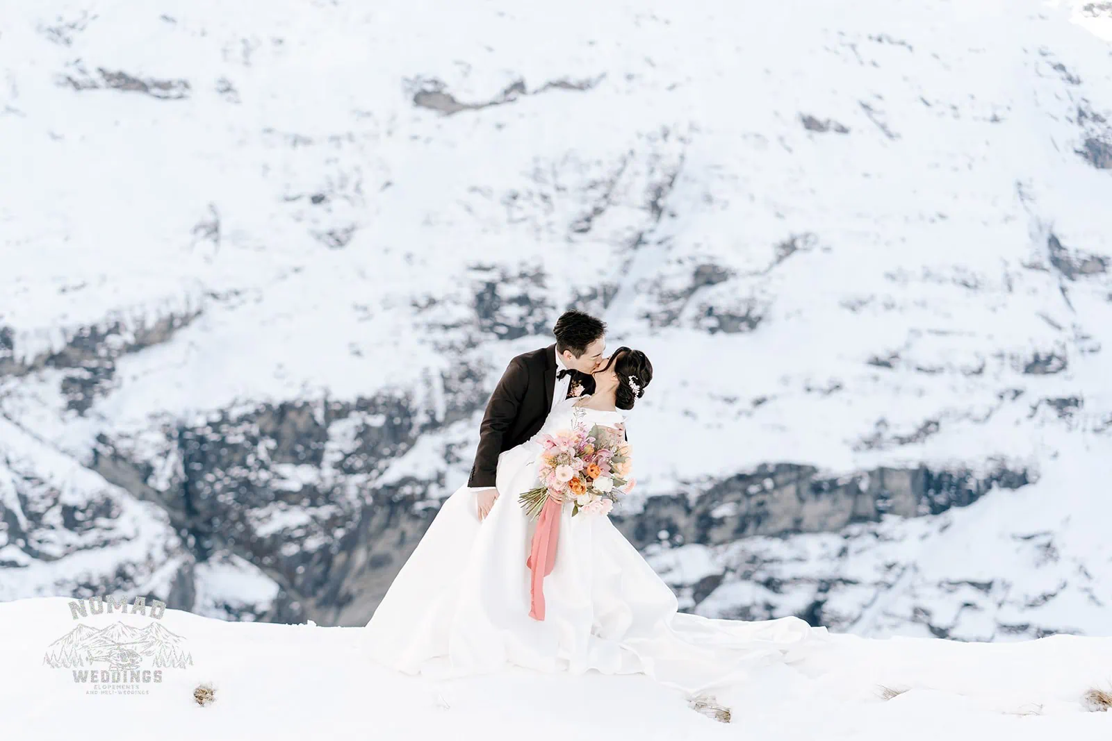 Queenstown New Zealand Elopement Wedding Photographer - A couple named Bo and Junyi share a kiss during their heli pre wedding shoot on a snow covered mountain with 4 landings.