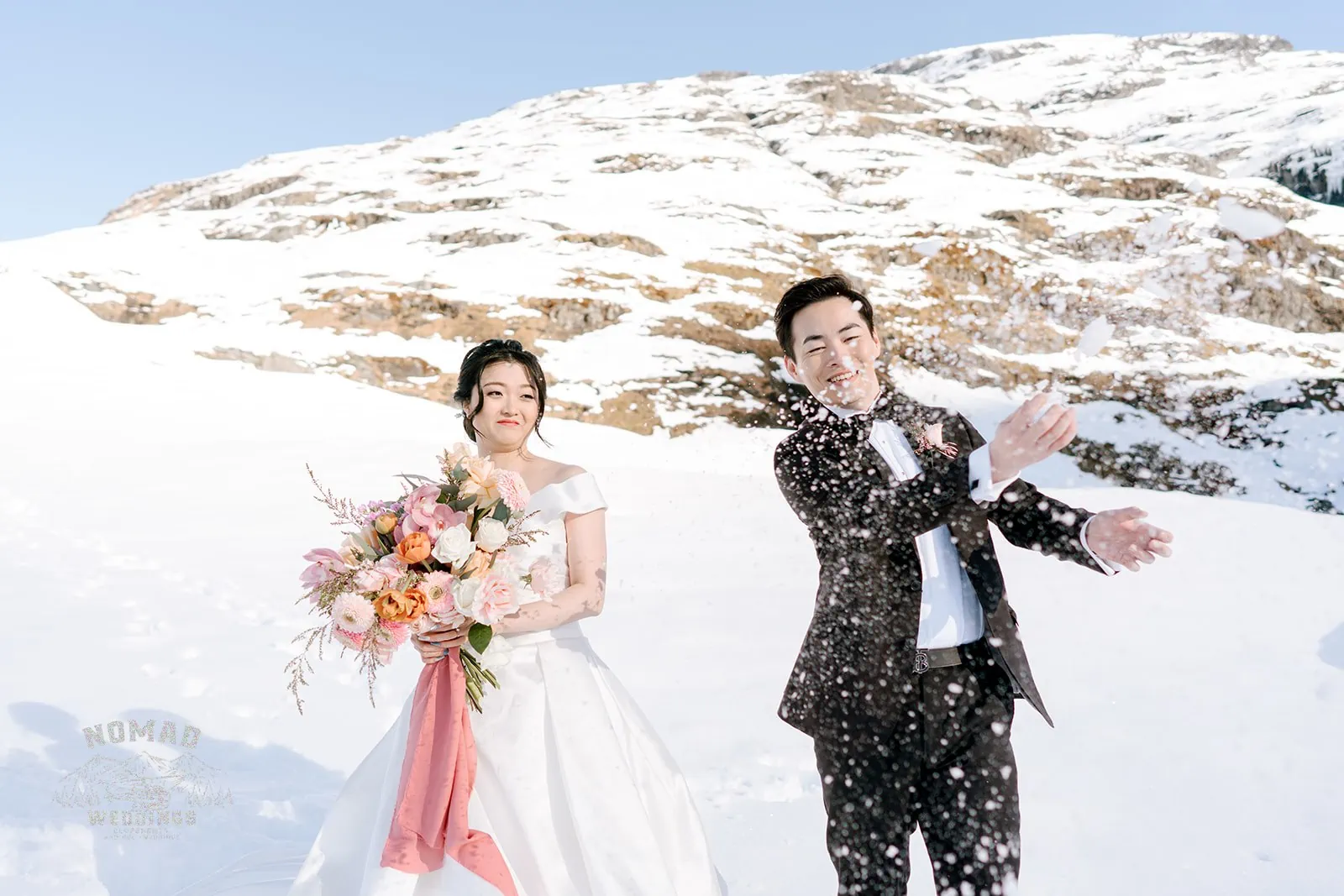Queenstown New Zealand Elopement Wedding Photographer - Bo and Junyi's Heli Pre Wedding Shoot captures a playful snow fight as the couple joyfully throws snow at each other.