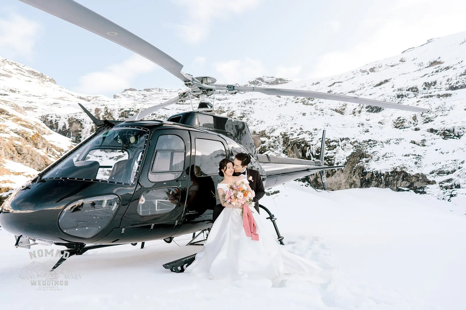Queenstown New Zealand Elopement Wedding Photographer - Bo and Junyi's pre-wedding shoot captured them standing next to a helicopter amidst snow.