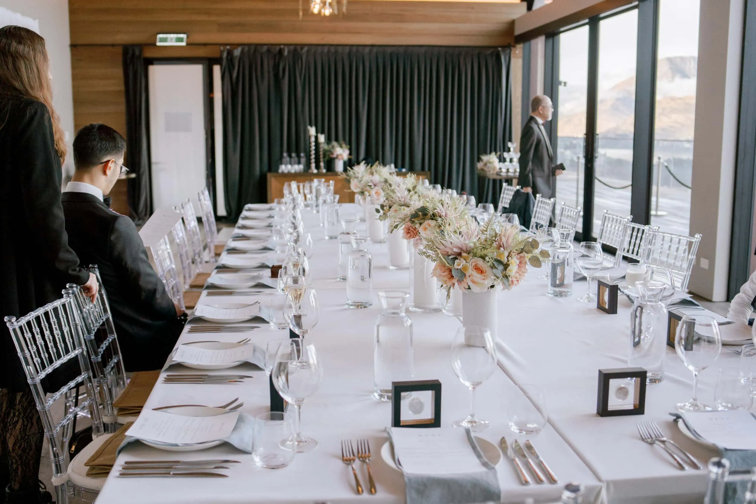 Queenstown New Zealand Elopement Wedding Photographer - A Lam and Wendy's wedding reception table set up in a room with large windows at Kamana Lakehouse.