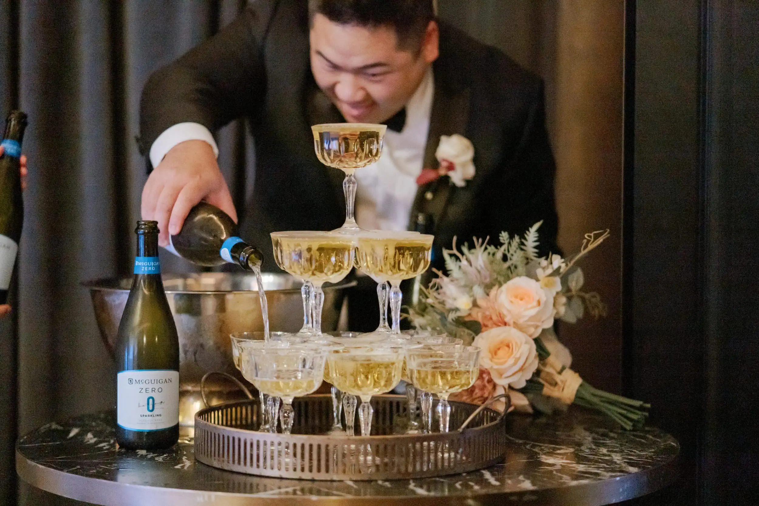 Queenstown New Zealand Elopement Wedding Photographer - A man pours champagne into a glass at Lam and Wendy's Kamana Lakehouse wedding.