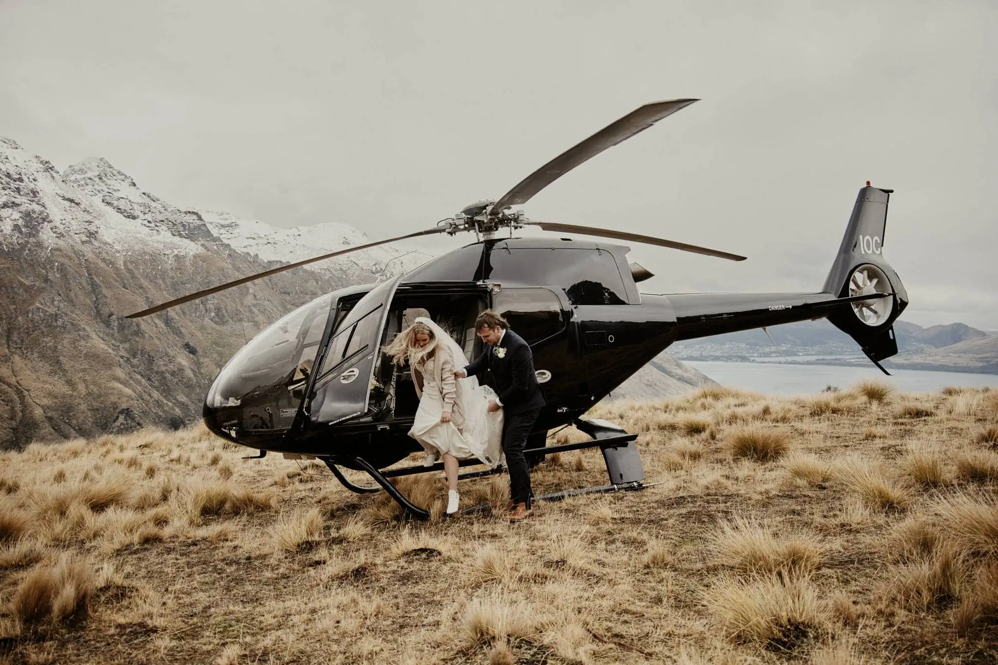 Queenstown New Zealand Elopement Wedding Photographer - Rebecca and Dylan sharing an enchanting Moke Lake elopement wedding near a helicopter.