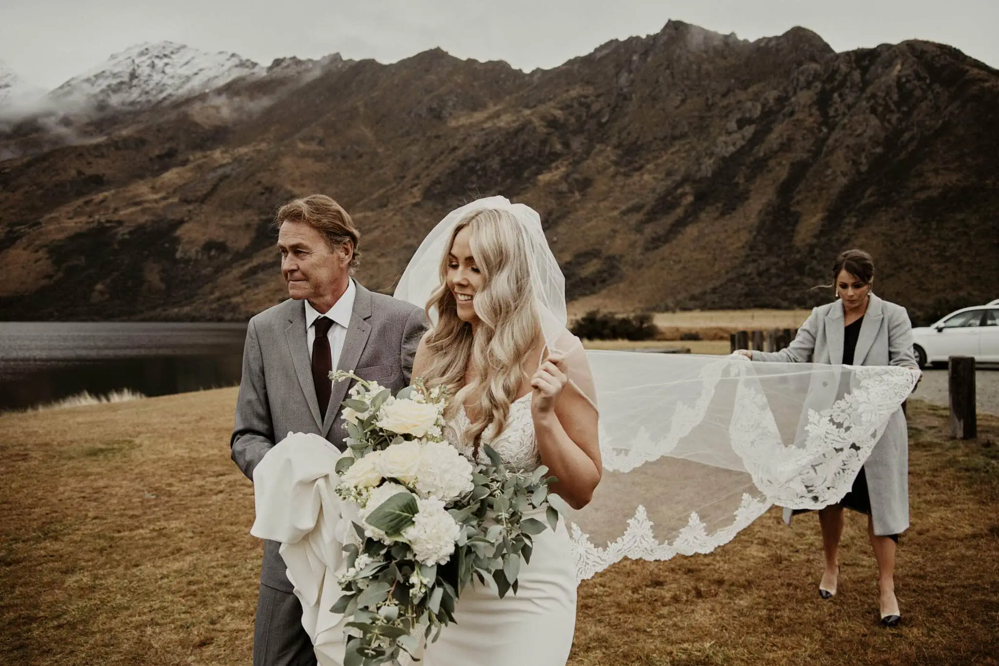 Queenstown New Zealand Elopement Wedding Photographer - Rebecca and Dylan delight in their enchanting Moke Lake elopement wedding as the bride walks down the aisle in New Zealand.