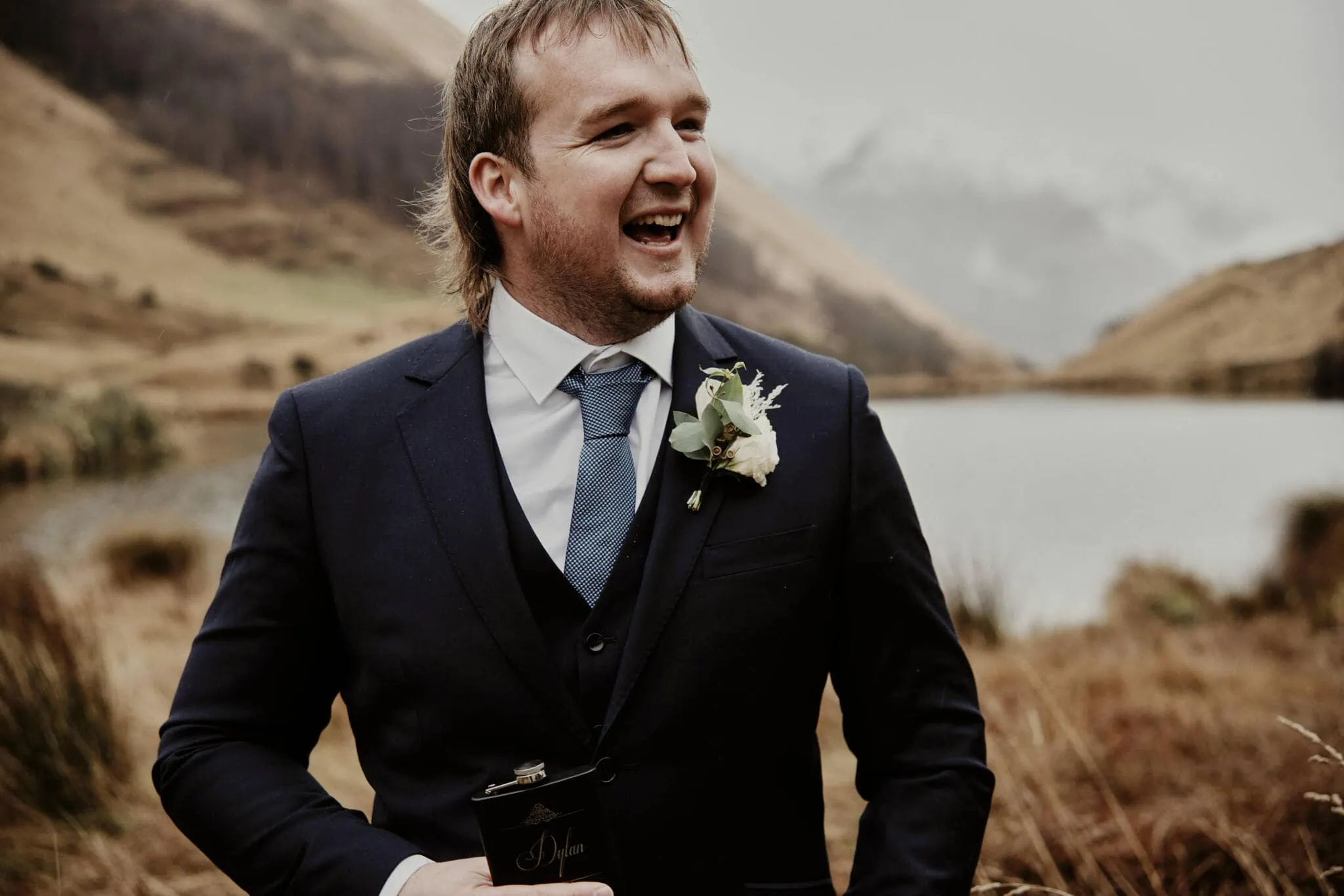 Queenstown New Zealand Elopement Wedding Photographer - A man in a suit is laughing during Rebecca and Dylan's enchanting Moke Lake elopement wedding.