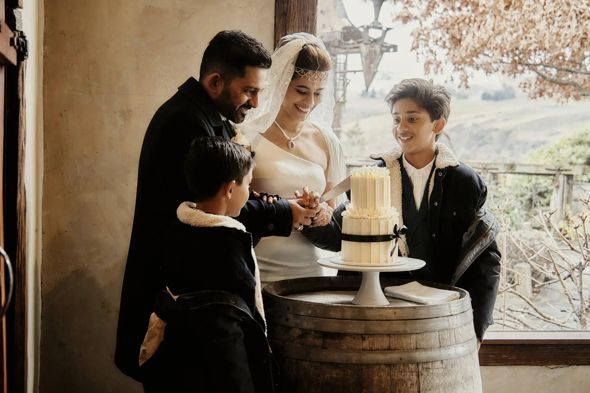 Queenstown New Zealand Elopement Wedding Photographer - Wasim and Yumn cutting a cake in front of a barrel at their Queenstown Islamic Wedding.