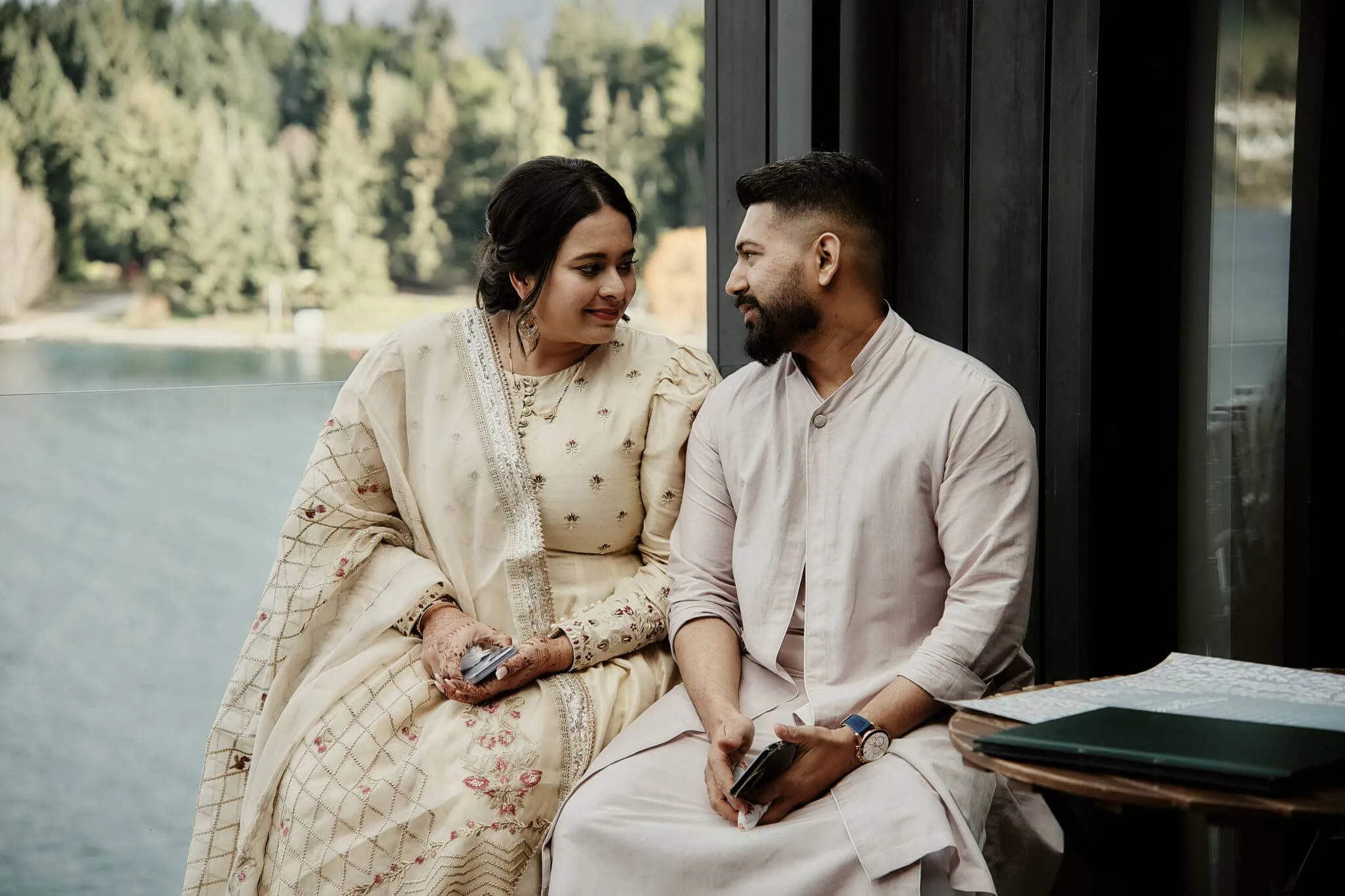 Queenstown New Zealand Elopement Wedding Photographer - Wasim and Yumn's Islamic wedding in Queenstown, with a man and woman sitting on a bench next to a lake.